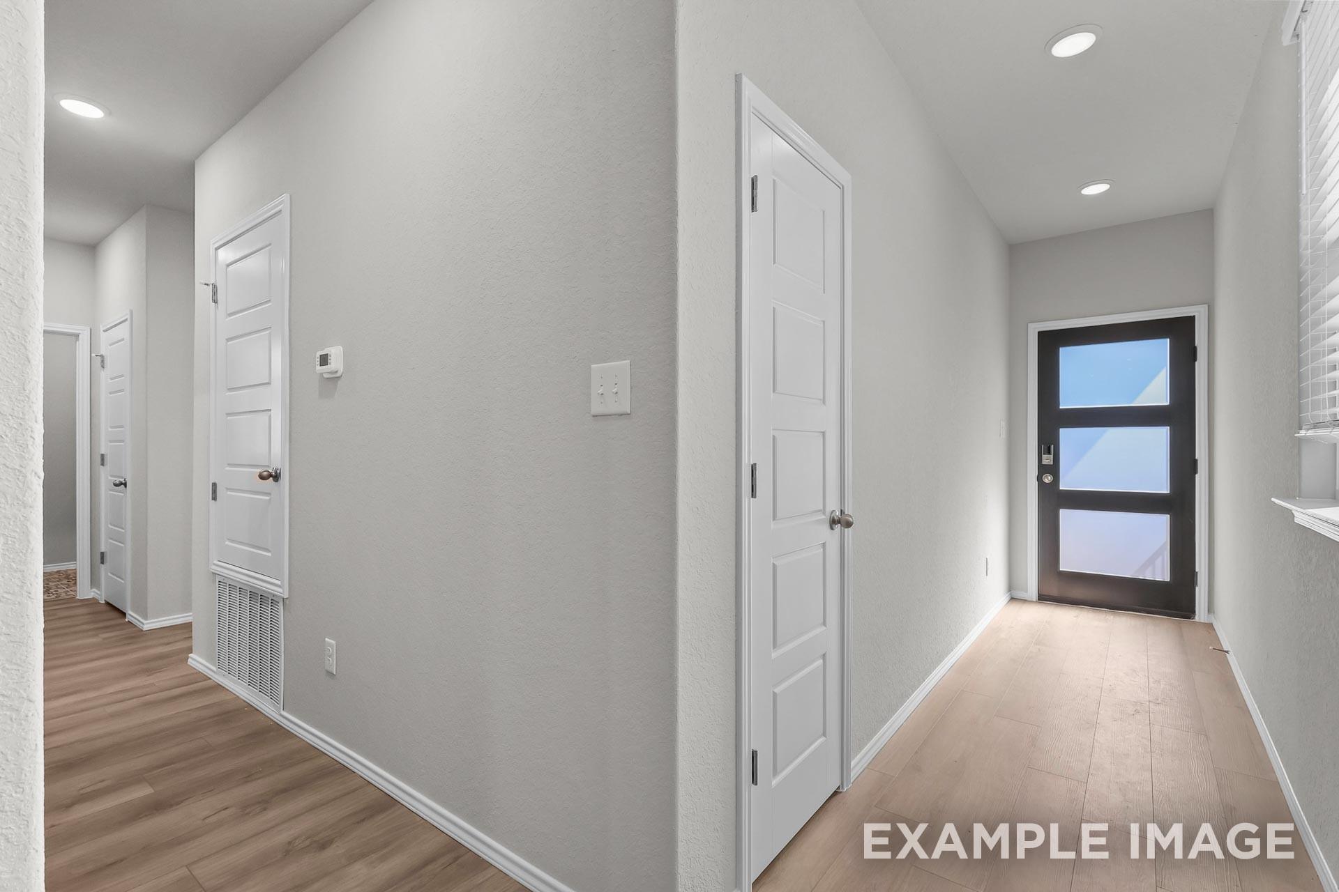 Bright open entryway with modern front door and wood-style flooring in Davidson Homes The Colorado G floor plan in Heartland