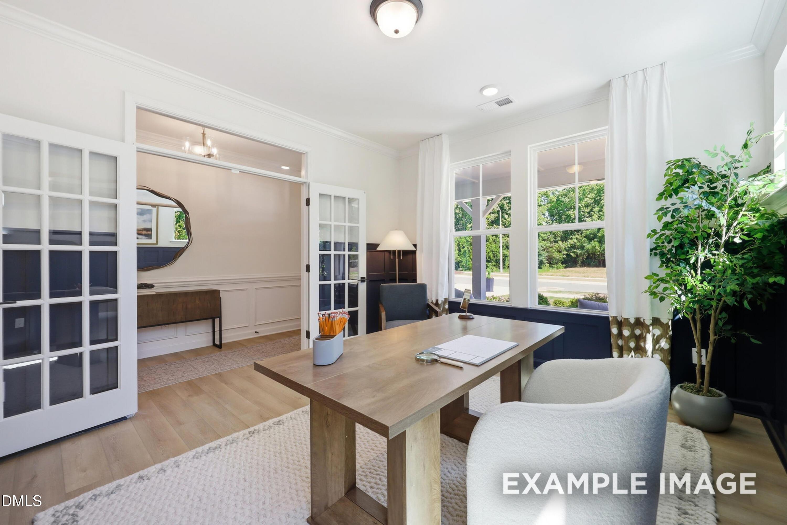 Bright home office with wood desk and French doors in The Aspen B floor plan by Davidson Homes in Wendell, North Carolina.