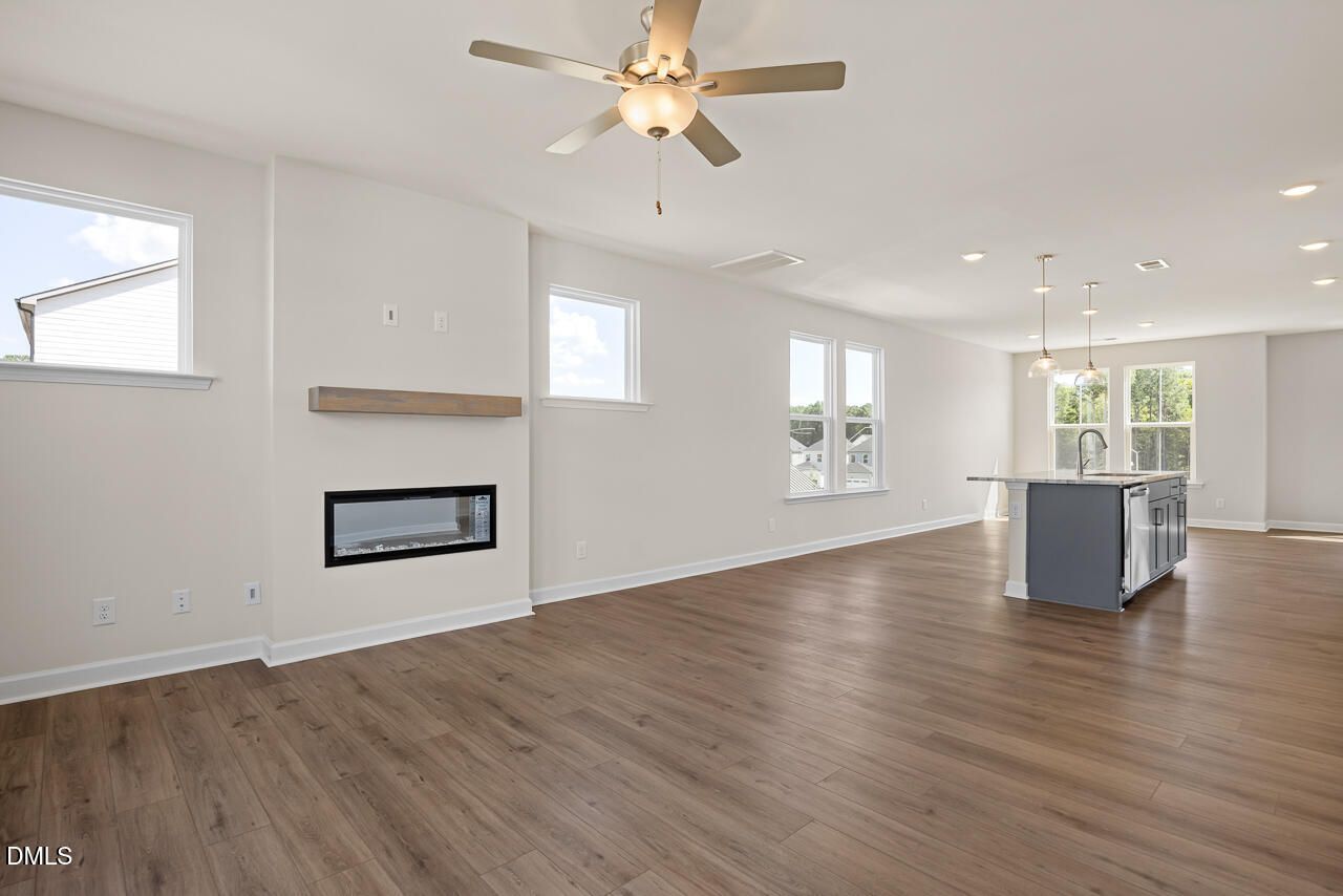 Open-concept living room with linear fireplace and kitchen island in Davidson Homes The Mitchell plan, Knightdale NC