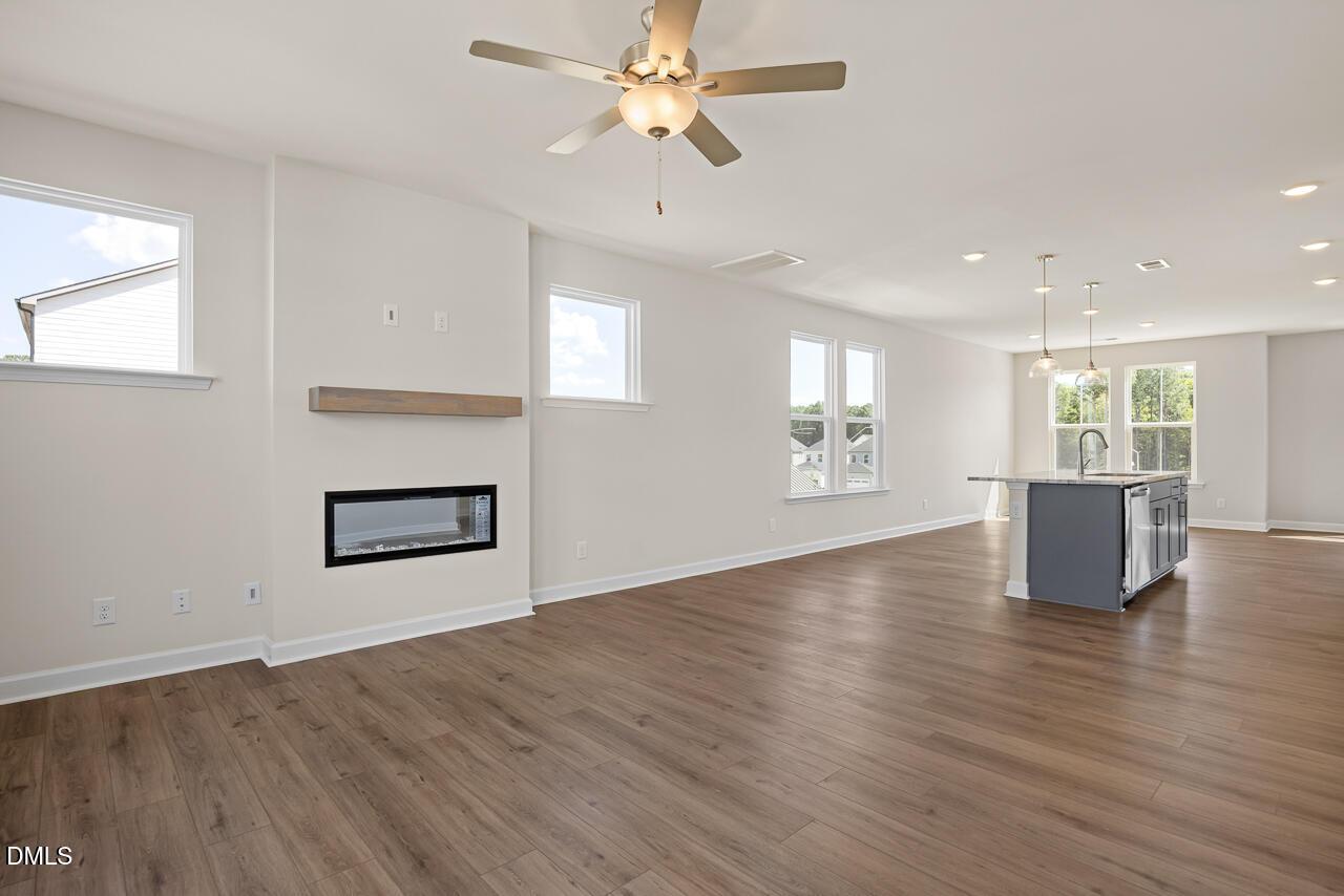 Open-concept living room with linear fireplace and kitchen island in Davidson Homes The Mitchell plan, Knightdale NC