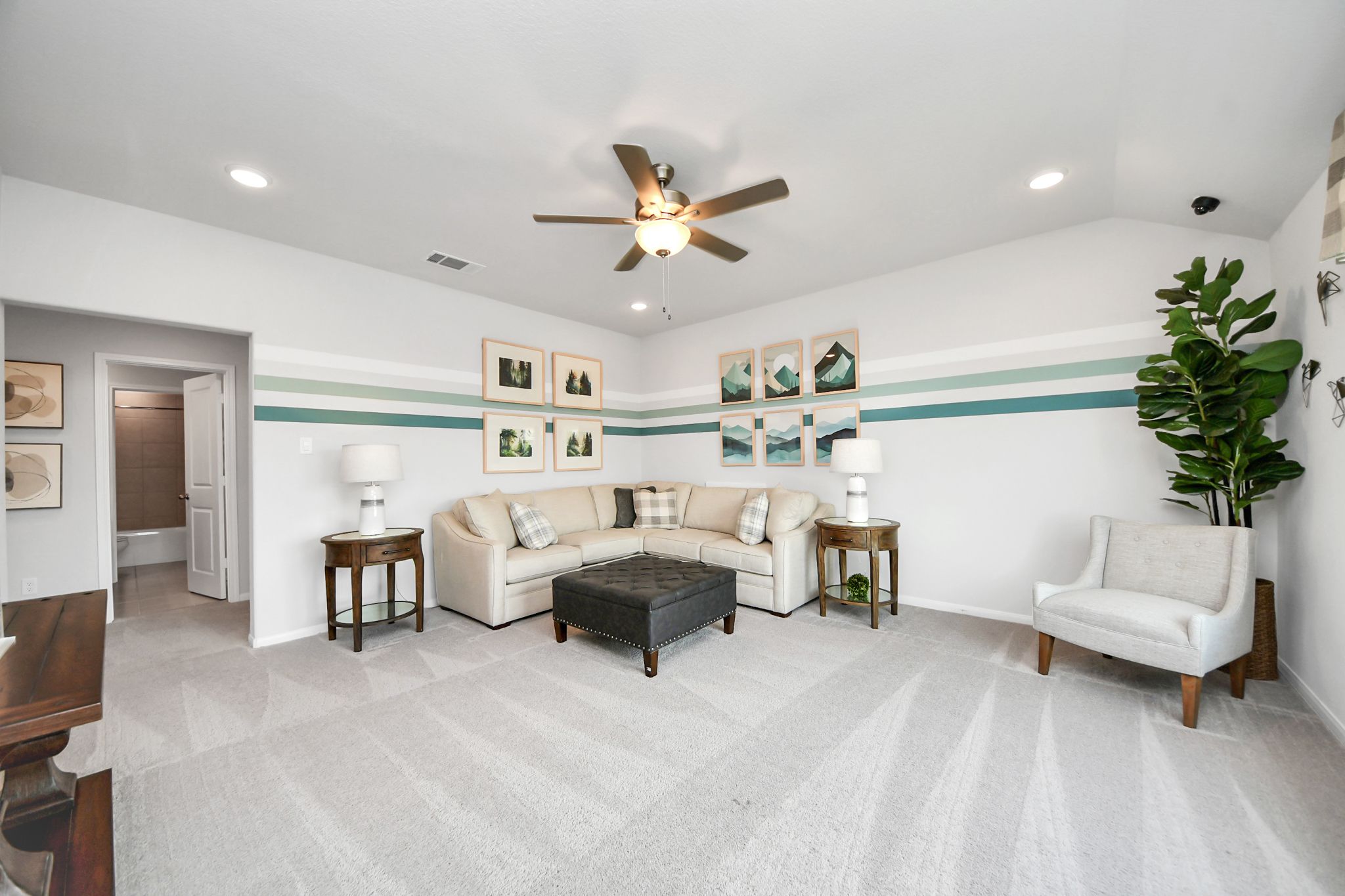 Cozy living room in a Sunterra home by Davidson Homes in Katy, Texas, featuring a sectional sofa and modern wall decor.