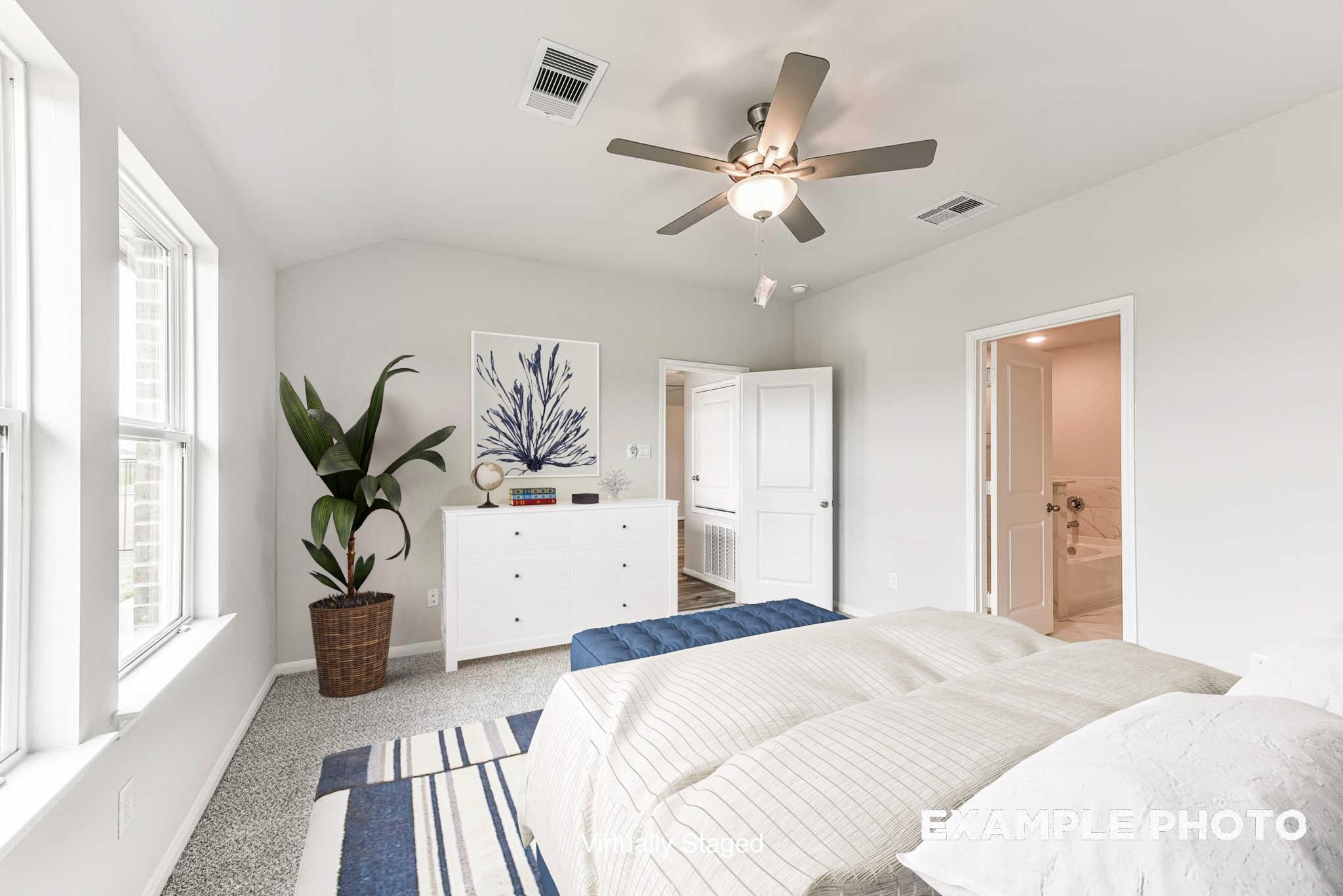 Bright primary bedroom with ceiling fan and en-suite bath in The Laguna C floor plan by Davidson Homes, Sunterra, Katy.