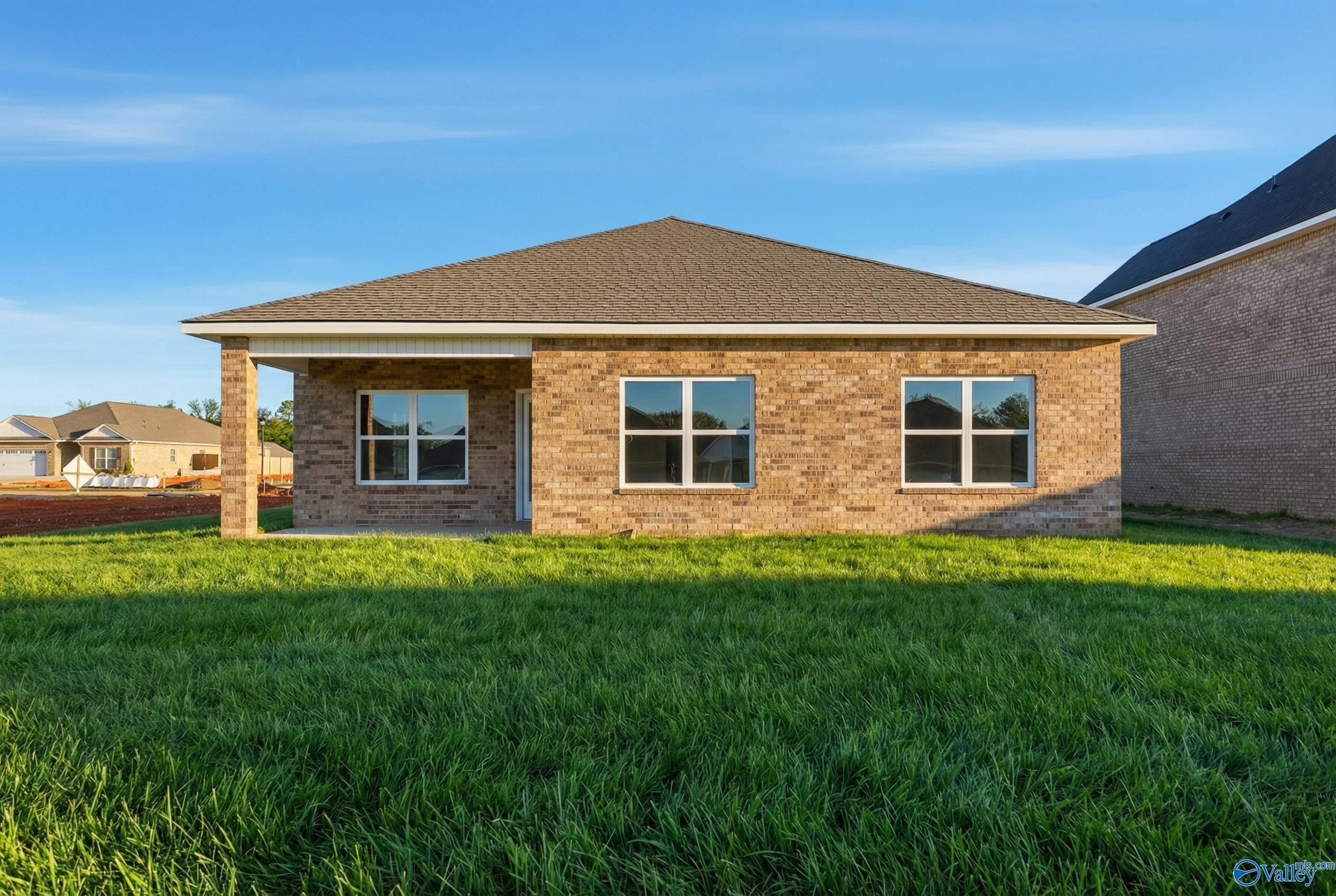 Single-story brick home with covered front porch, large windows, and lush green lawn in Creek Grove, New Market, Alabama - Davidson Homes Franklin C
