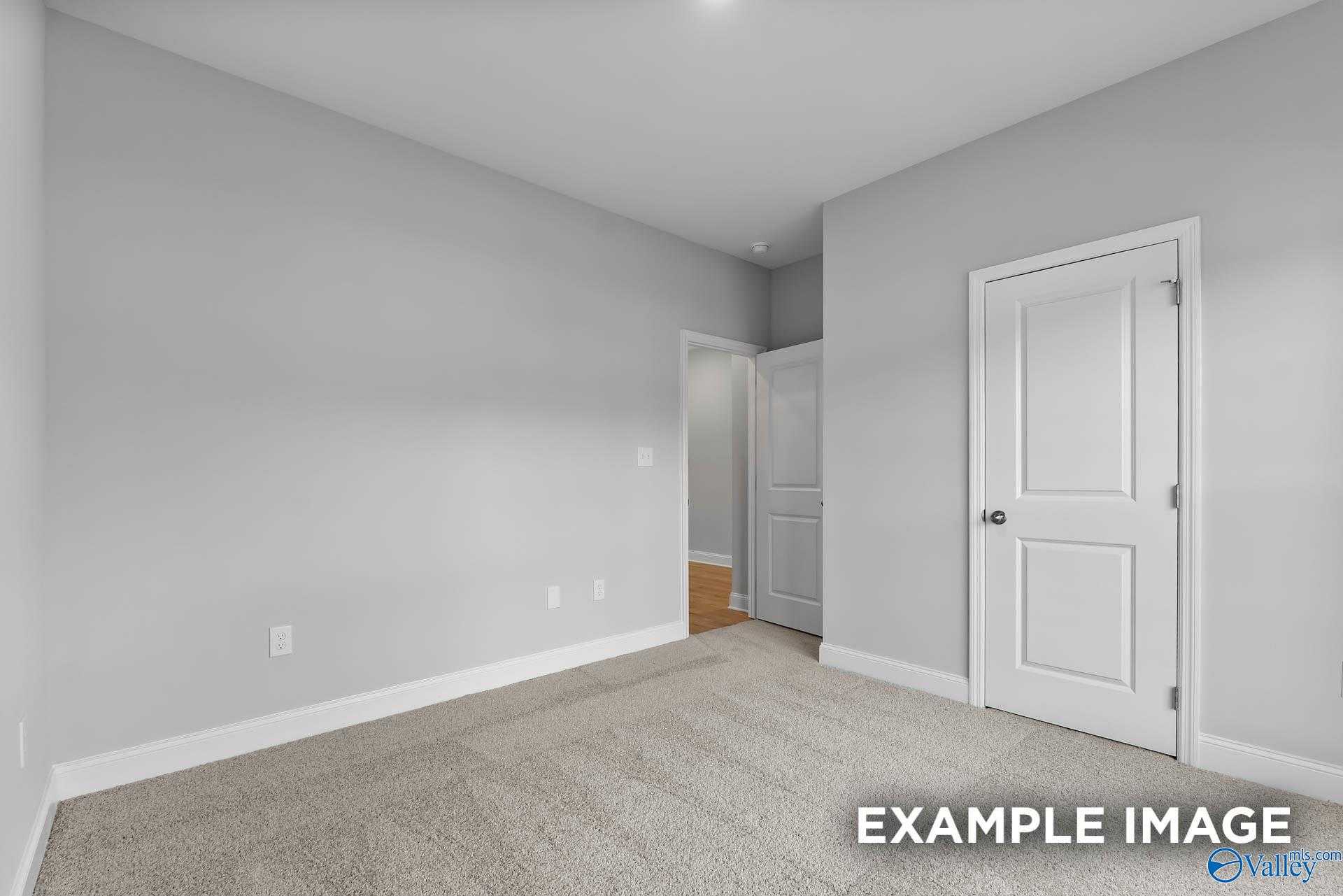 Bright secondary bedroom with gray walls, carpeted floor, and open doorway in Davidson Homes The Franklin C, Athens, Alabama