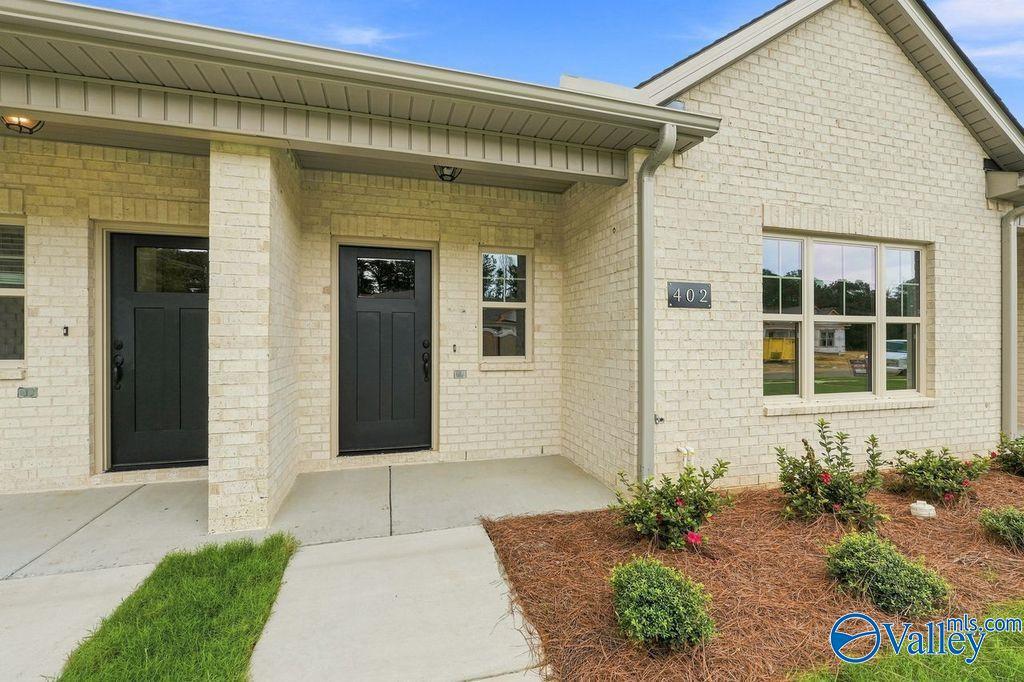 Cream brick exterior and covered front porch of The Camilla C floor plan in The Retreat at Cain Park, Hartselle, Alabama.