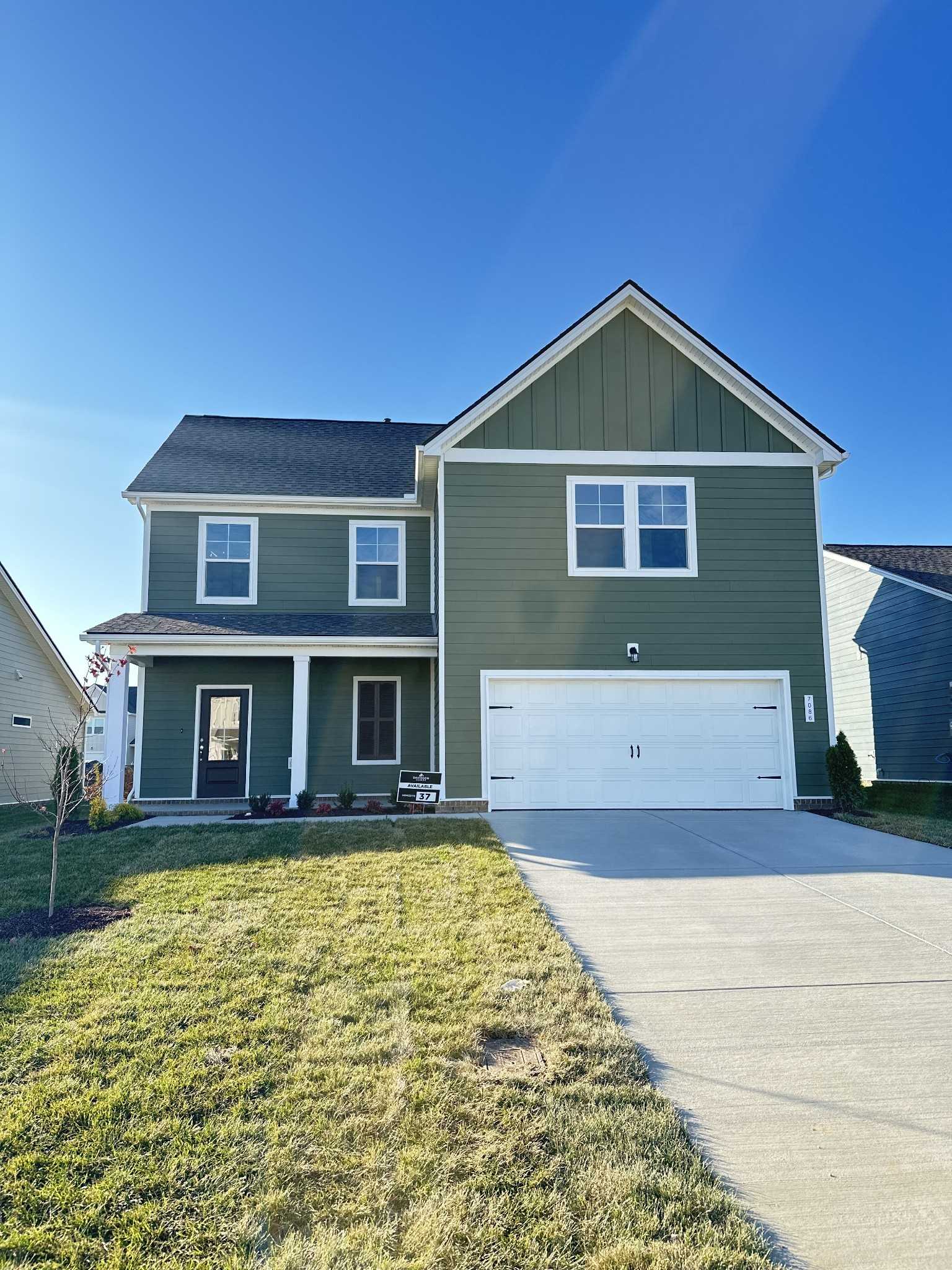 Two-story green home with 2-car garage, front porch, and manicured lawn in Sage Farms, White House, Tennessee - Davidson Homes The Gordon A