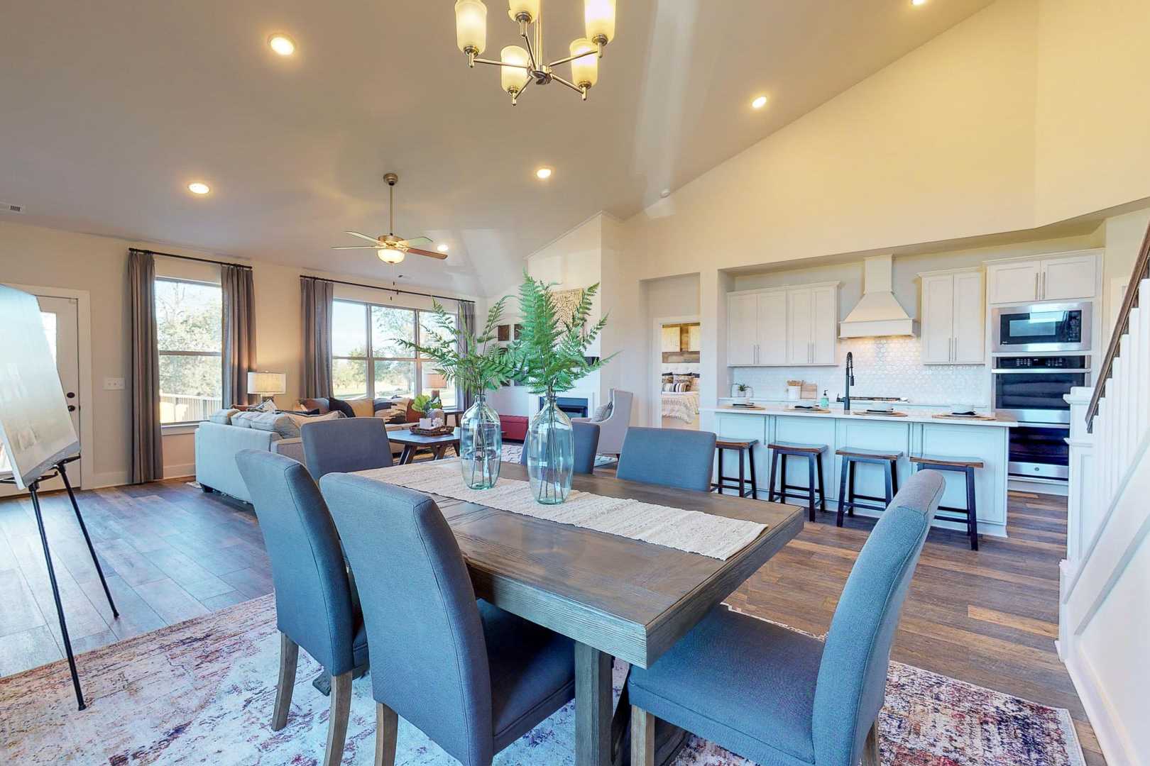 Spacious open-concept kitchen dining area at Liberty Creek in Gallatin TN with hardwood floors white cabinets and chandelier