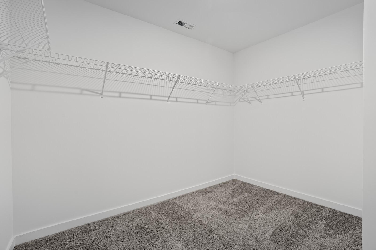 Spacious empty walk-in closet with wire shelving and carpeted floor in The Logan C master suite, Davidson Homes, White House, TN