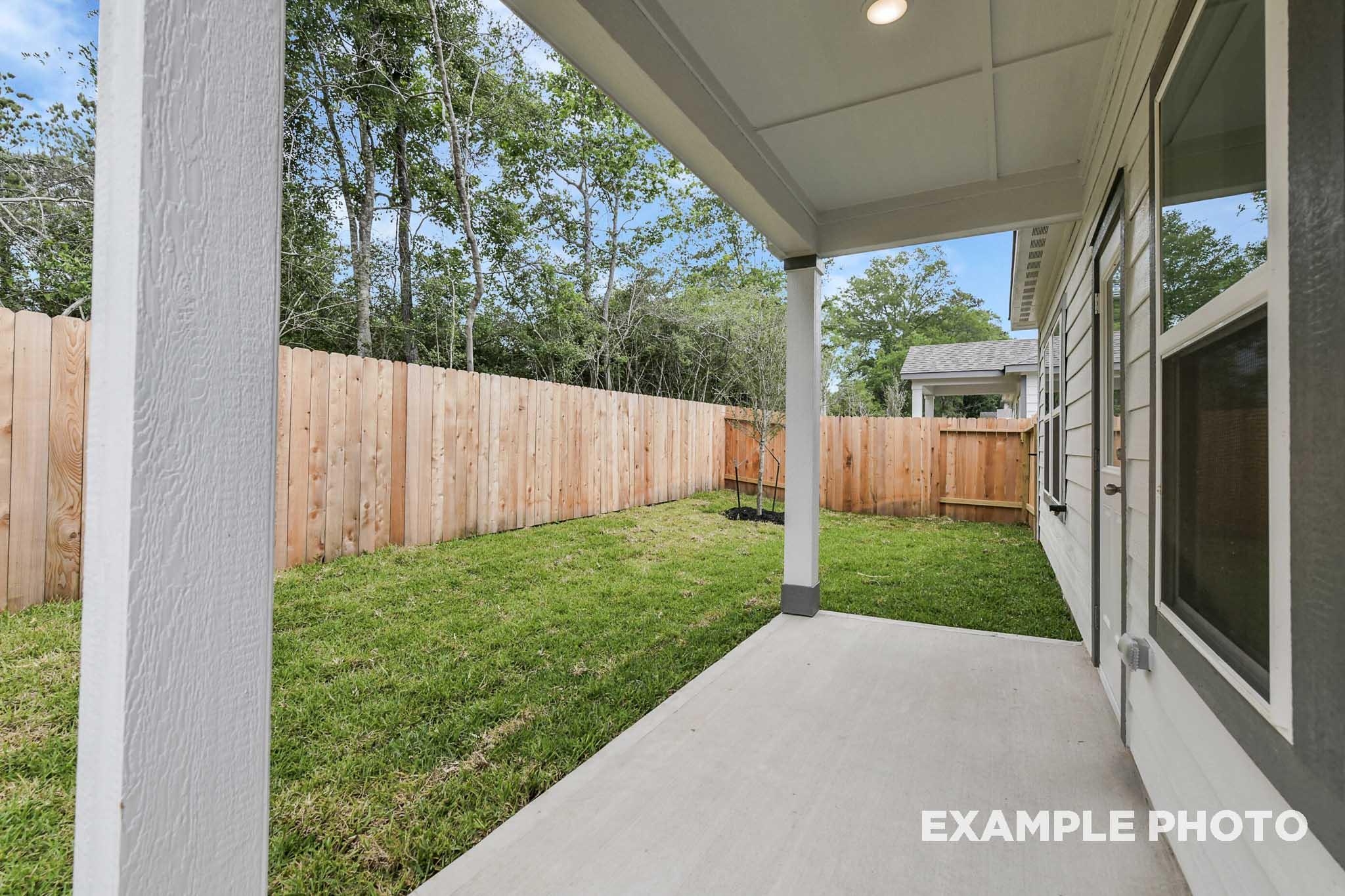 Covered patio and private fenced backyard of The Frio home design by Davidson Homes in Conroe, Texas.