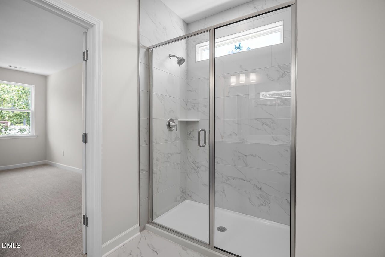 Modern tiled walk-in shower with glass door in Hickory II B floor plan at Montrose, Aberdeen, North Carolina.