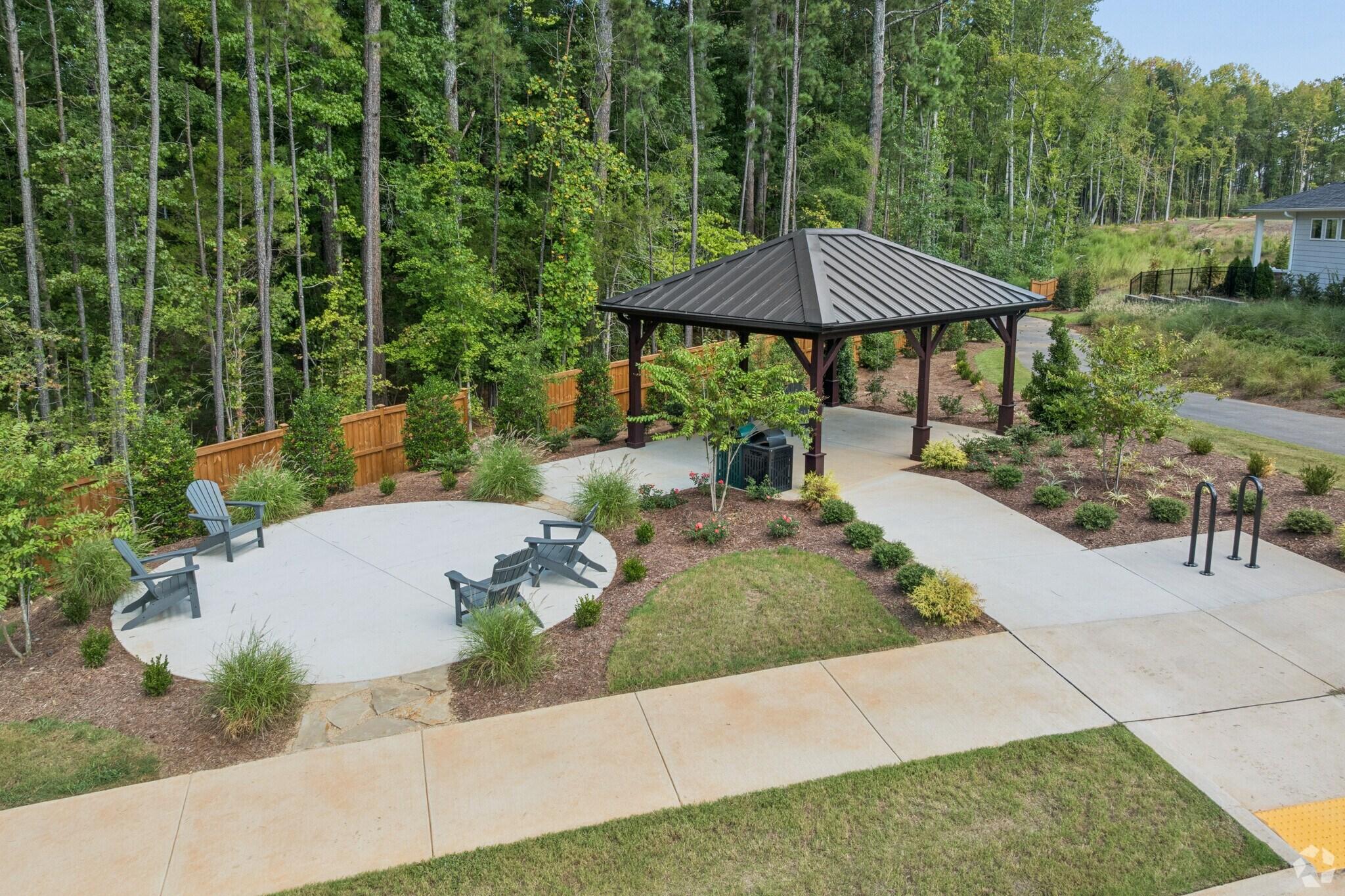 Community pavilion with Adirondack chairs and landscaped patio at Sage on North Main in Wake Forest, NC by Davidson Homes