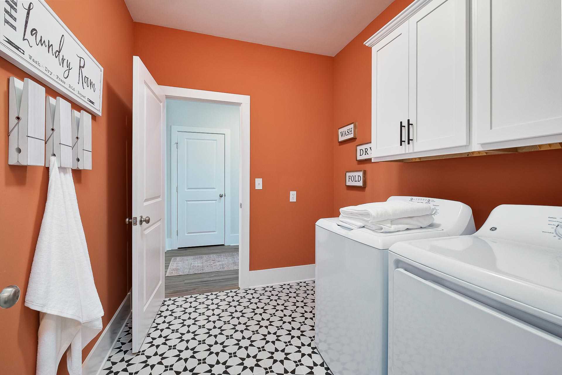 cheerful laundry room with black and white tile floor