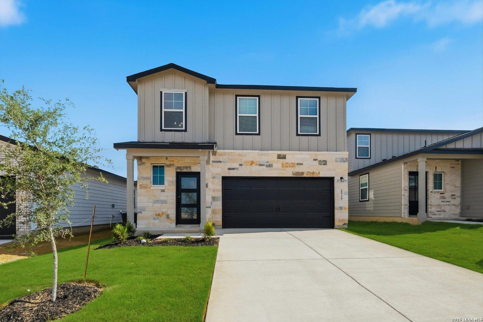 Modern Trinity C 4-bedroom home exterior with stone facade, 2-car garage, and landscaped yard in Agave, San Antonio, Texas
