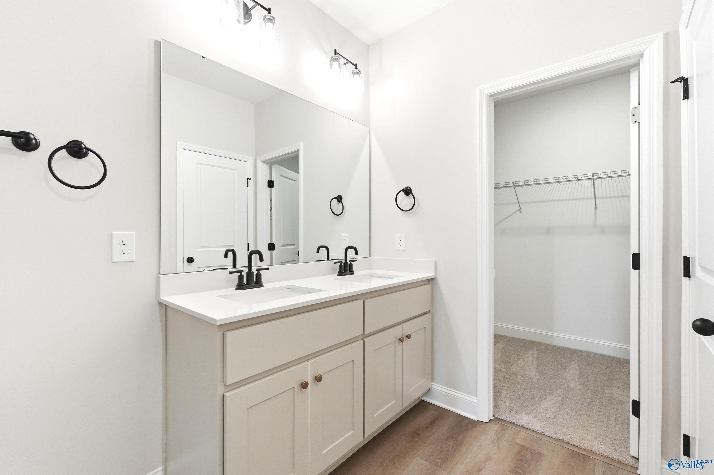 Dual-vanity bathroom with modern fixtures and walk-in closet in The Franklin floor plan at Ricketts Farm, Athens, Alabama.