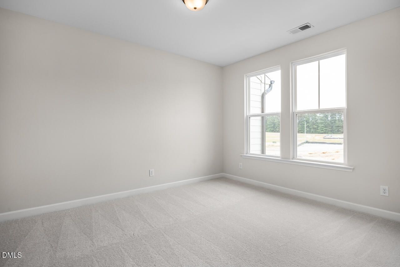 Bright, carpeted bedroom with large windows in The Avery Interior floor plan at Forestville Yard Townhomes in Knightdale.