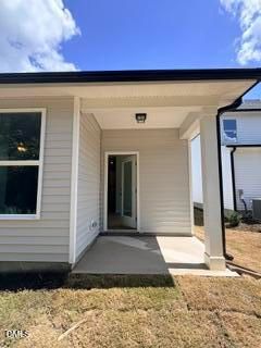 Covered concrete patio entrance of The Daphne D floor plan by Davidson Homes in Woodland Crossing, Zebulon, North Carolina.
