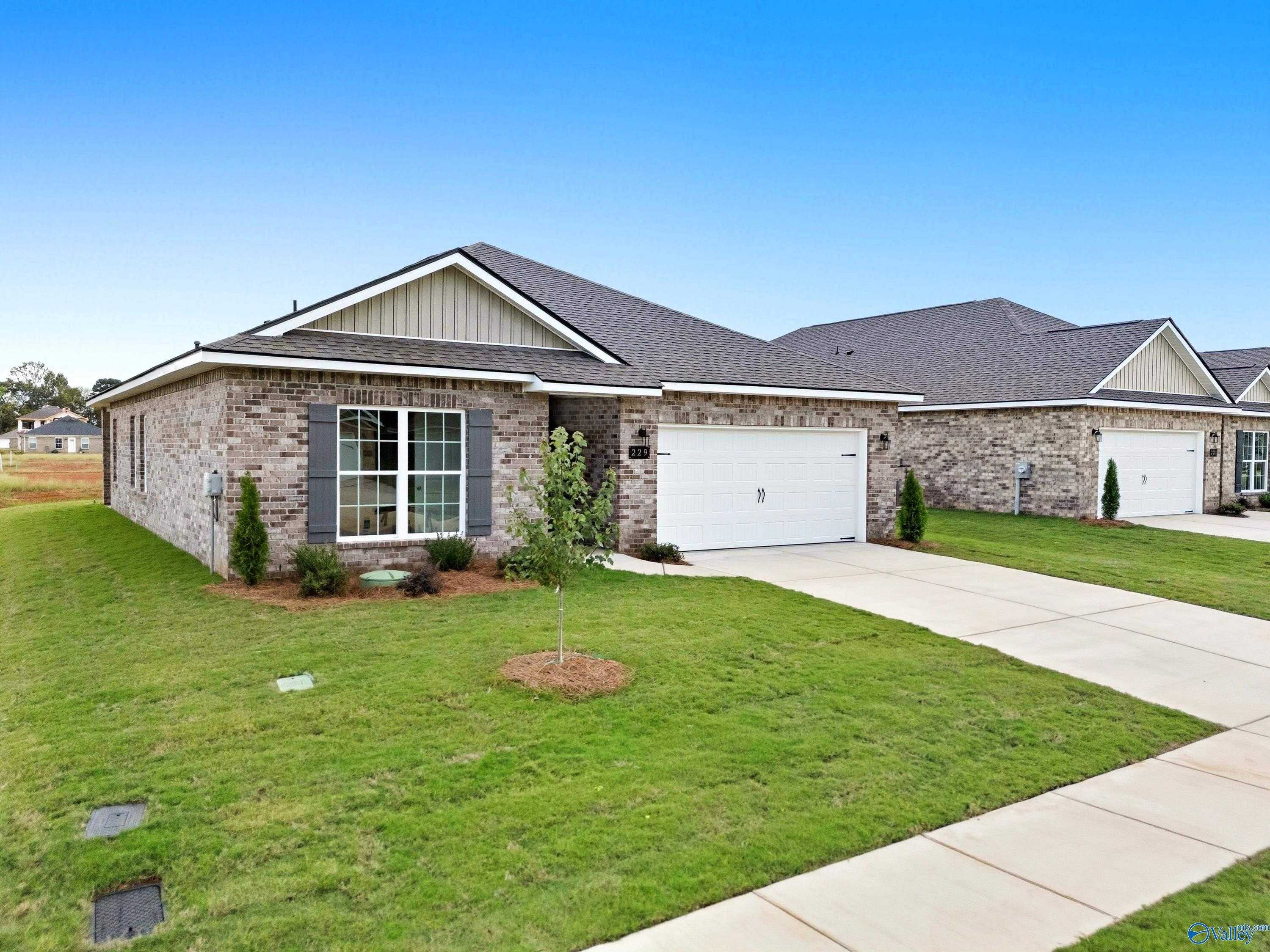 Brick ranch home with 2-car garage, large windows, and landscaped yard in Lynn Meadows, Meridianville, Alabama - Davidson Homes The Franklin