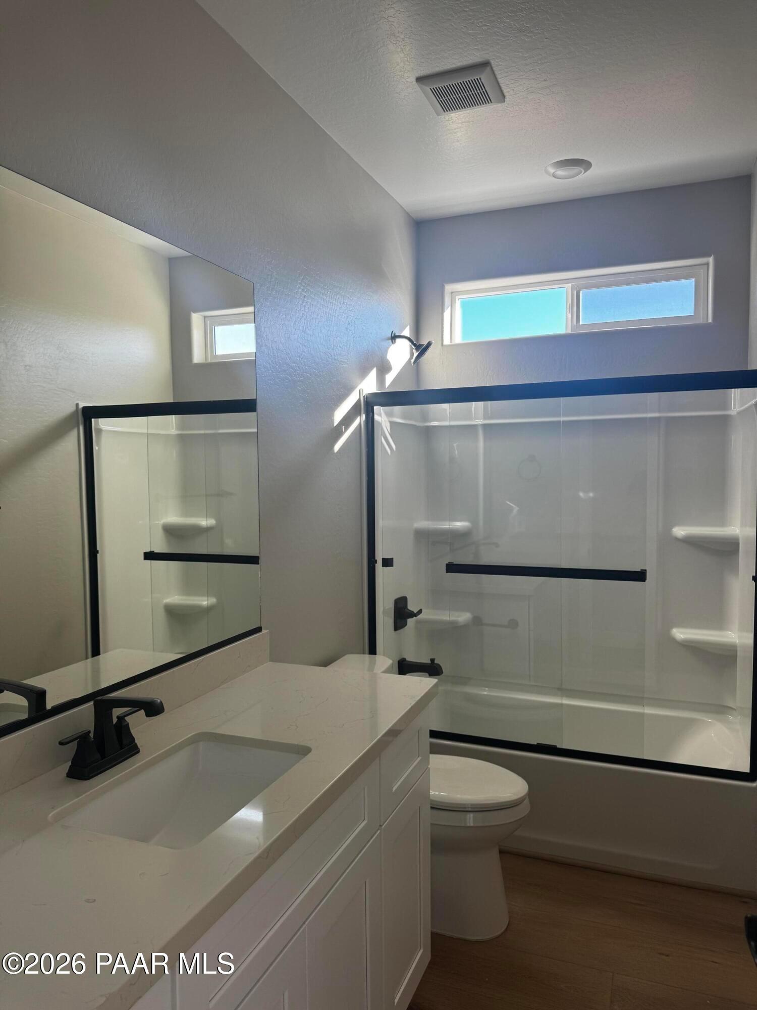 Modern master bathroom with frameless glass shower, soaking tub, white vanity sink, and natural light in Evermore Homes The Monarch B, Prescott Valley