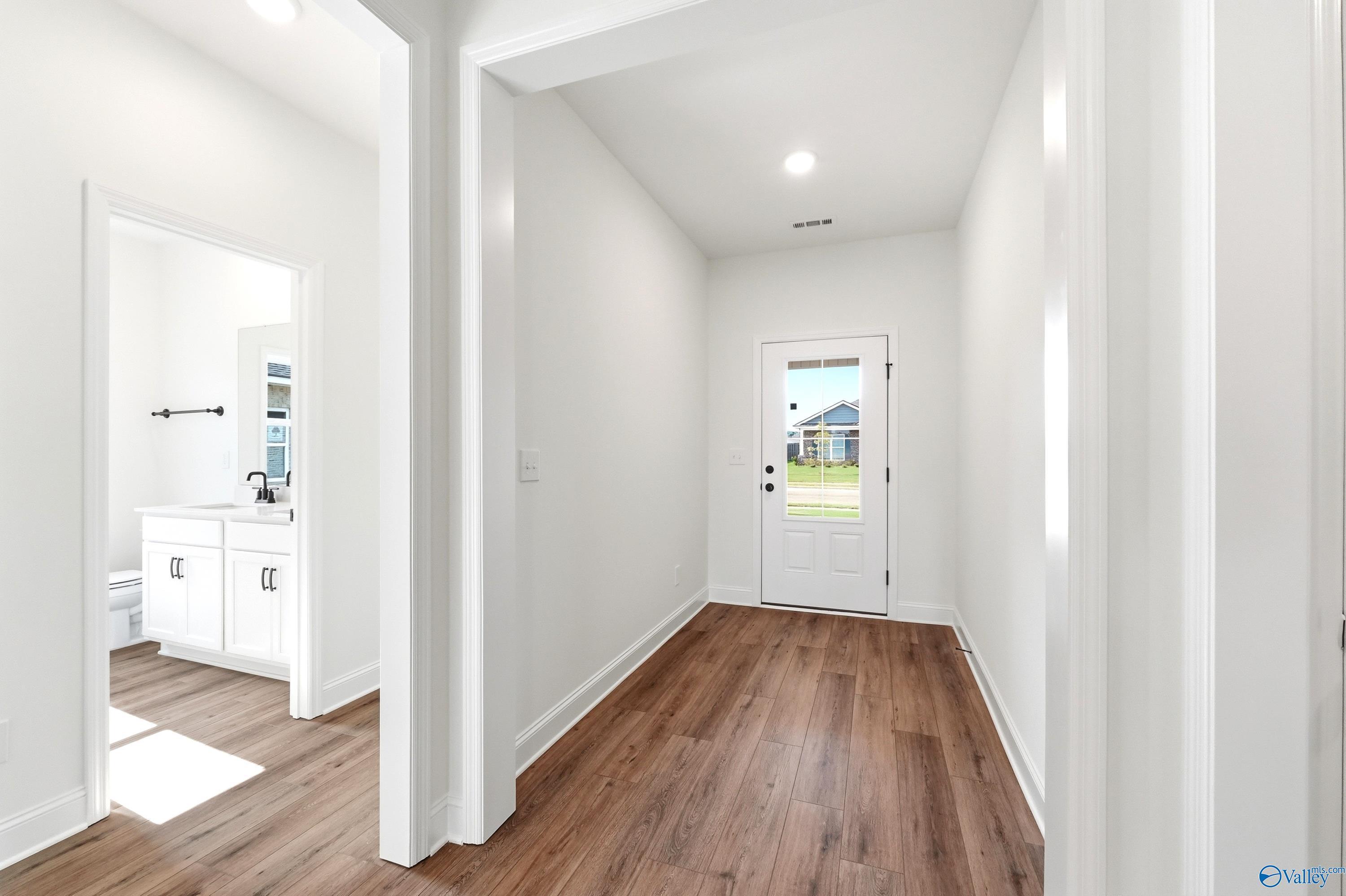 Bright entryway and hallway leading to a bathroom in The Everett B floor plan by Davidson Homes in Clearview, Alabama.
