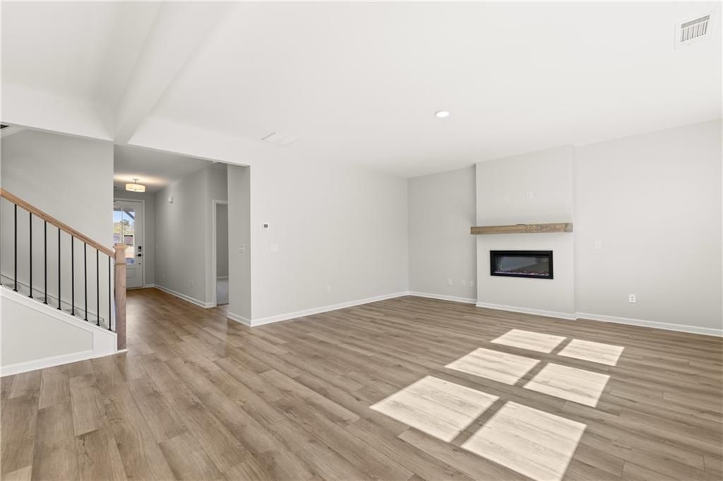 Spacious foyer with gas fireplace, hardwood floors, and open staircase in The Hickory B by Davidson Homes, Winder, GA