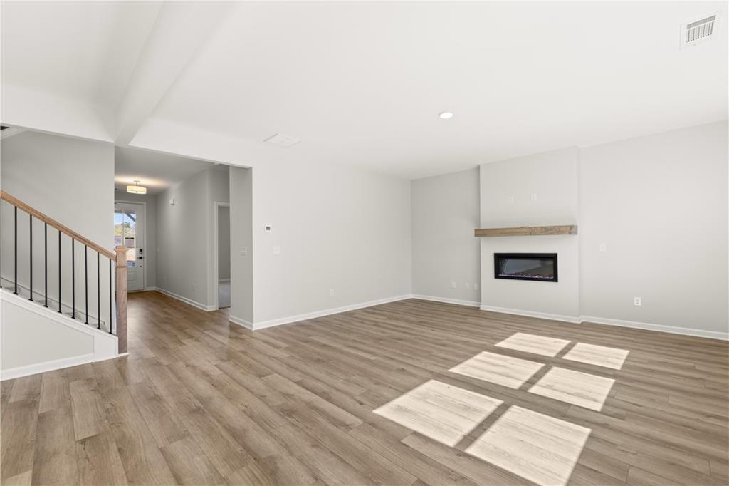 Spacious foyer with gas fireplace, hardwood floors, and open staircase in The Hickory B by Davidson Homes, Winder, GA