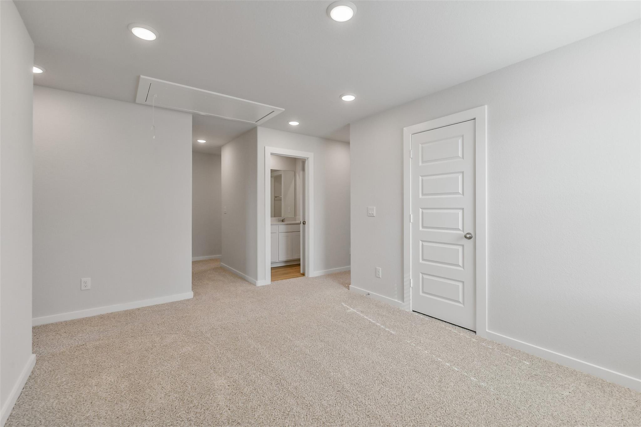 Spacious secondary bedroom with en-suite bathroom and beige carpet in Davidson Homes The Trinity F, Magnolia, Texas