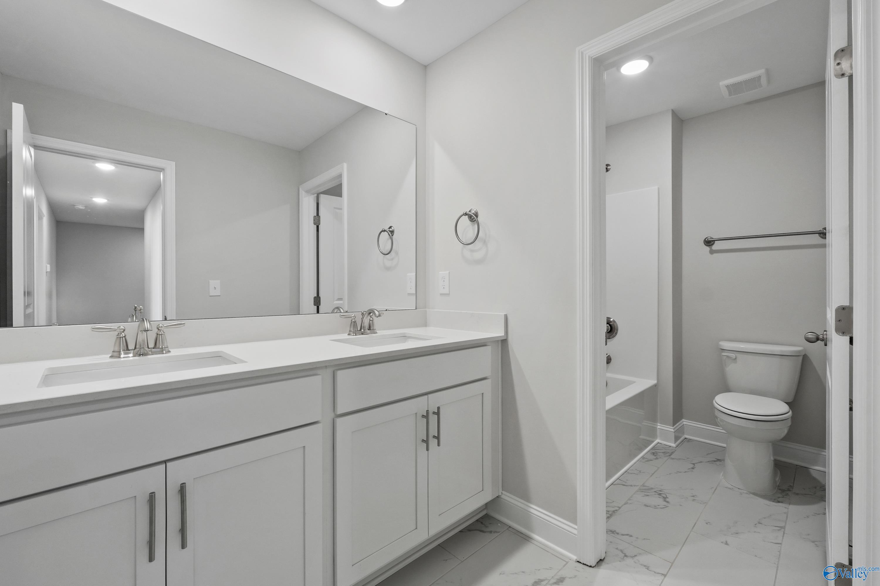 Elegant master bathroom with double vanity, soaking tub, and glass shower in Davidson Homes The Camden, Huntsville, Alabama