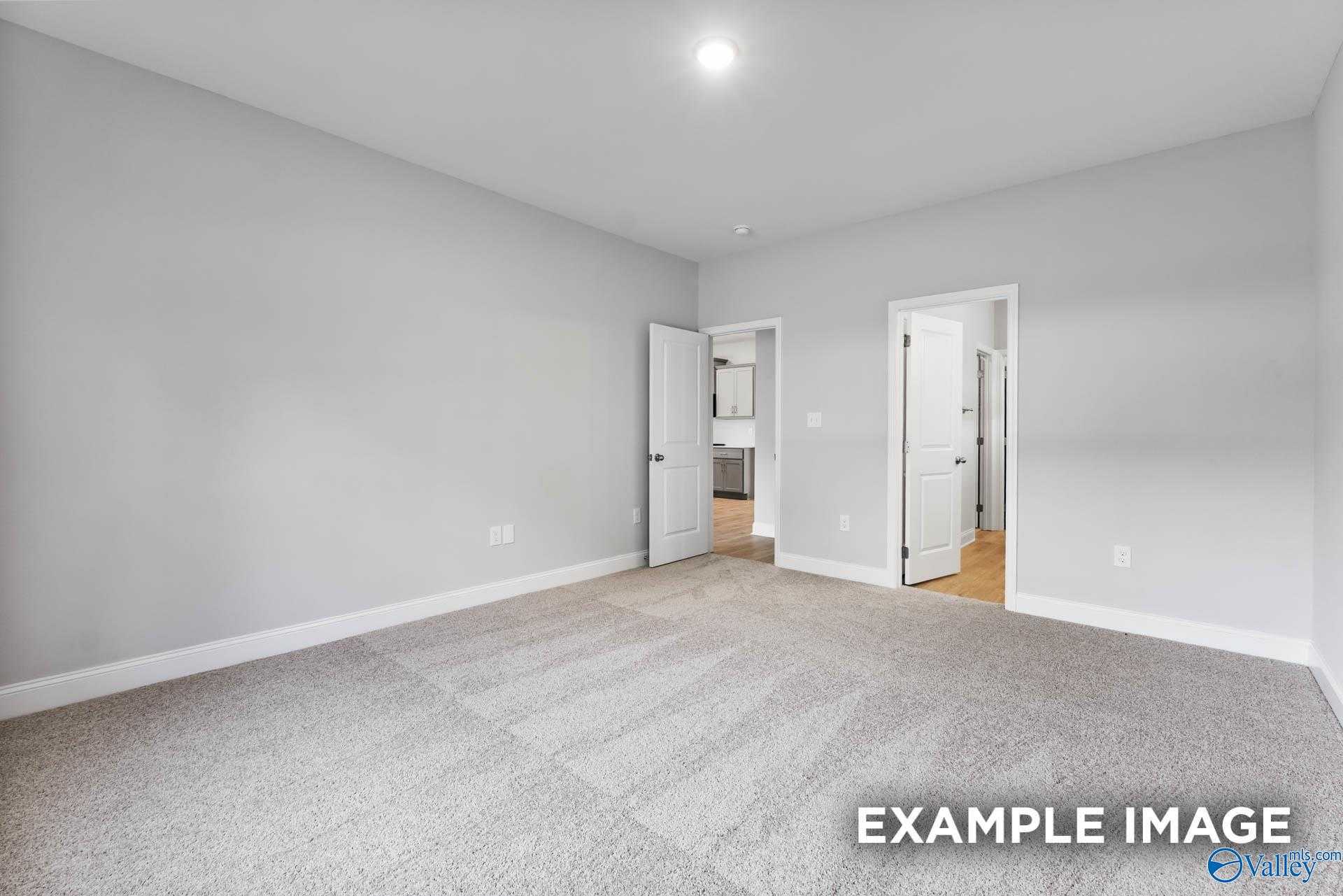 Empty secondary bedroom with attached bath, gray walls, and plush carpet in Davidson Homes The Daphne C, New Market, AL
