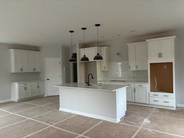 Modern white shaker kitchen with large island, black pendants, subway tile backsplash in Davidson Homes Rabun C, Winder GA