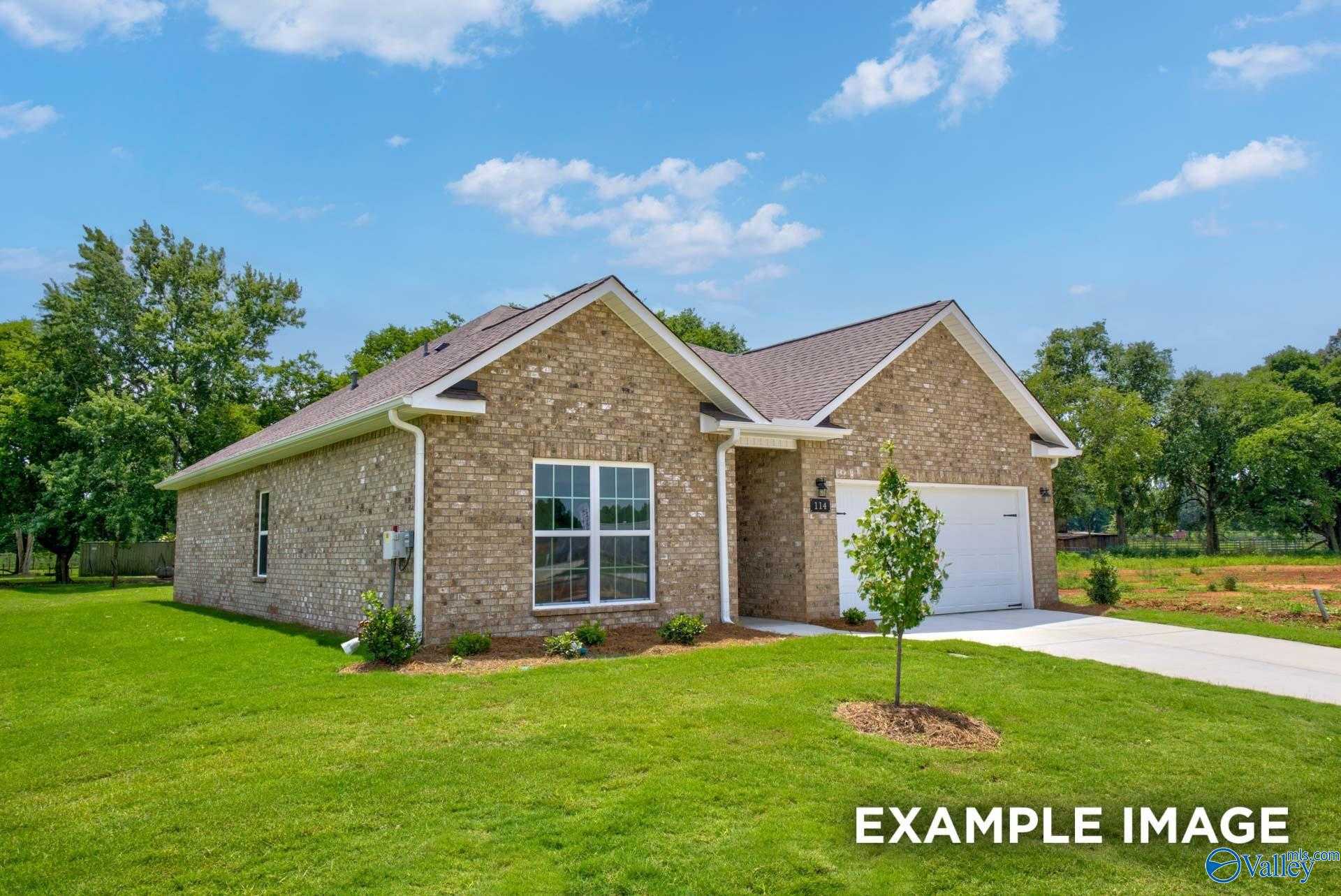 Brick single-story home with gabled roof, 2-car garage, large windows, green lawn, and trees in Lynn Meadows, Meridianville, Alabama