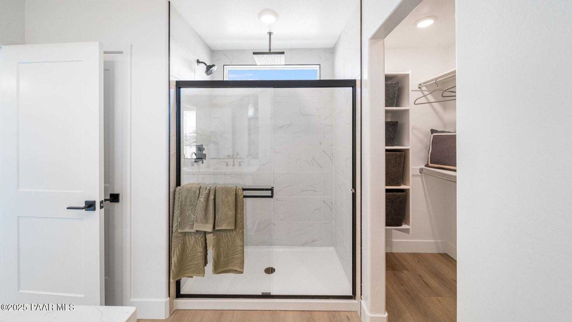 Modern master bath with frameless glass shower, subway tiles, and walk-in closet in Davidson Homes Wilmington B, Prescott AZ