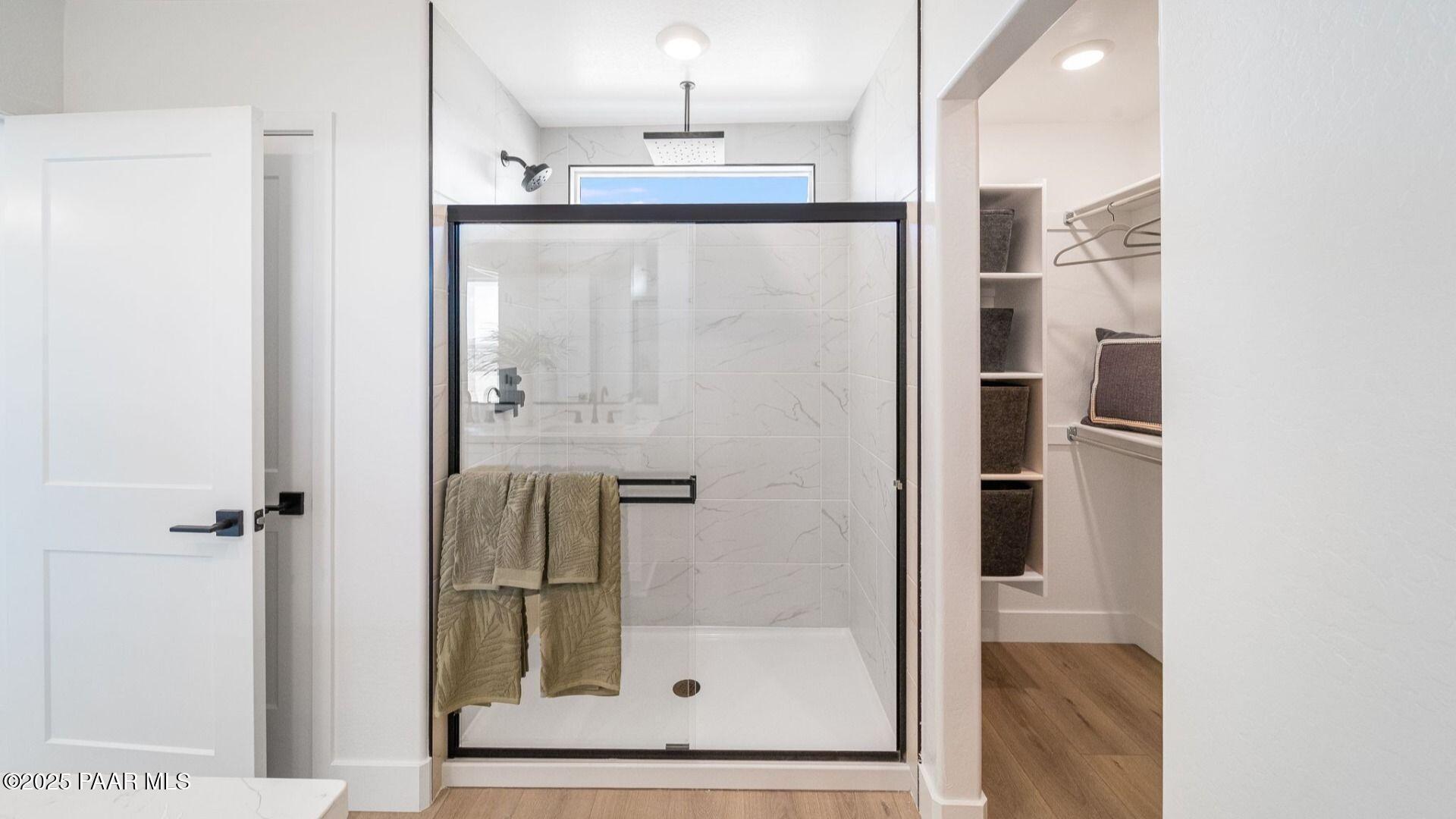 Modern master bath with frameless glass shower, subway tiles, and walk-in closet in Davidson Homes Wilmington B, Prescott AZ