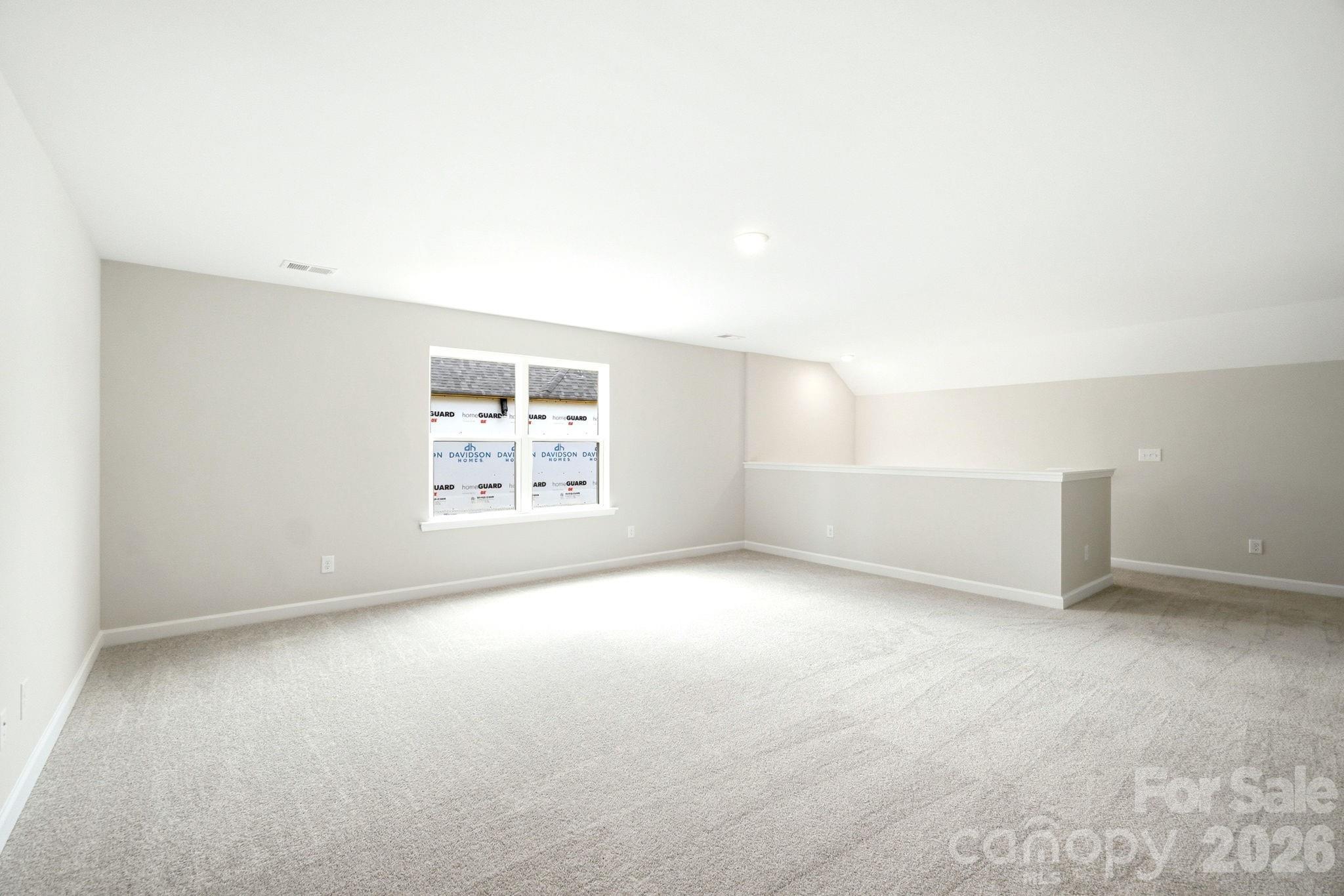 Spacious carpeted loft area in The Magnolia B floor plan by Davidson Homes in Windgate, Mooresville, North Carolina.
