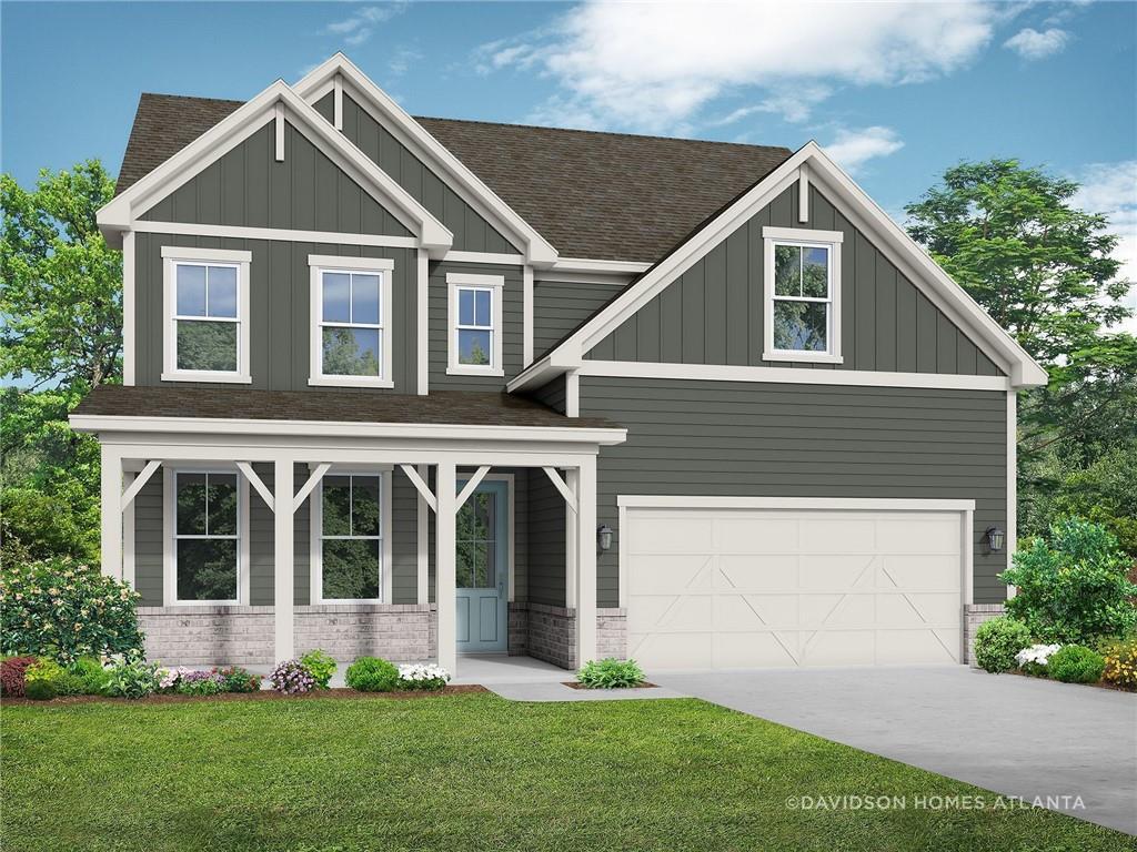 Modern two-story gray home with shakeboard siding, covered front porch, and two-car garage in lush landscaped yard, Cedar Farms, Winder, Georgia - The Hickory B by Davidson Homes