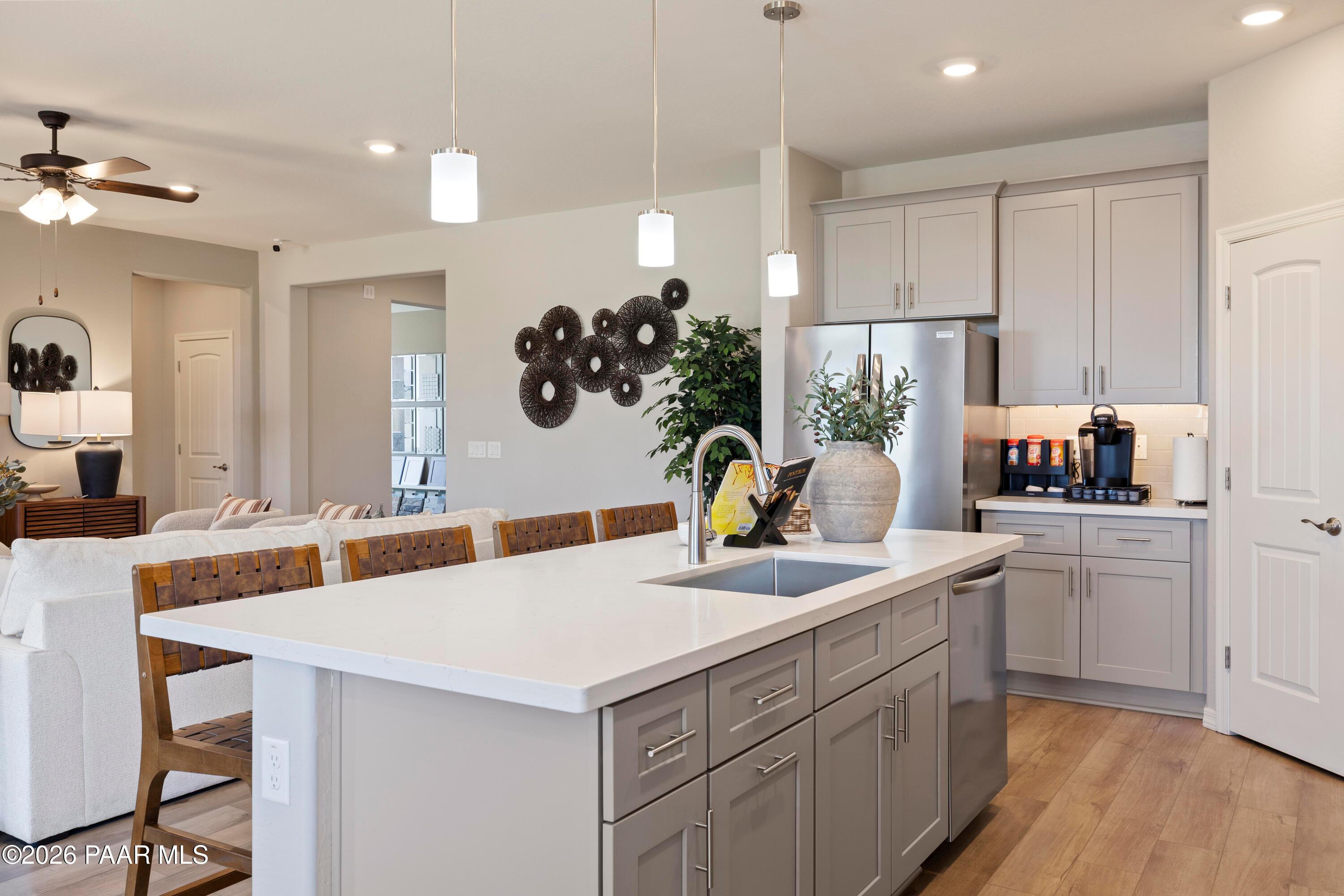 Modern kitchen with large island, stainless steel appliances, and grey cabinetry in The Harmony A plan at Pronghorn Ranch.