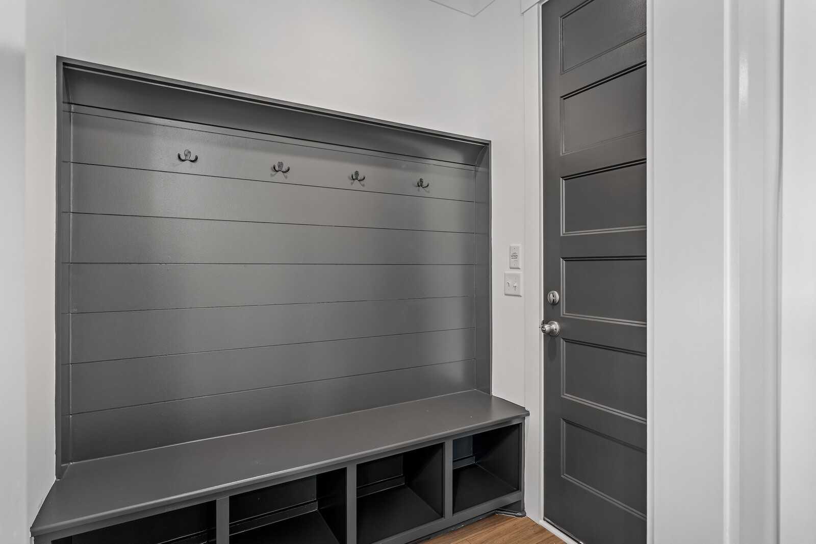 Gray shiplap mudroom with coat hooks, built-in bench, and storage cubbies in Davidson Homes The Hawkins, Murfreesboro, Tennessee
