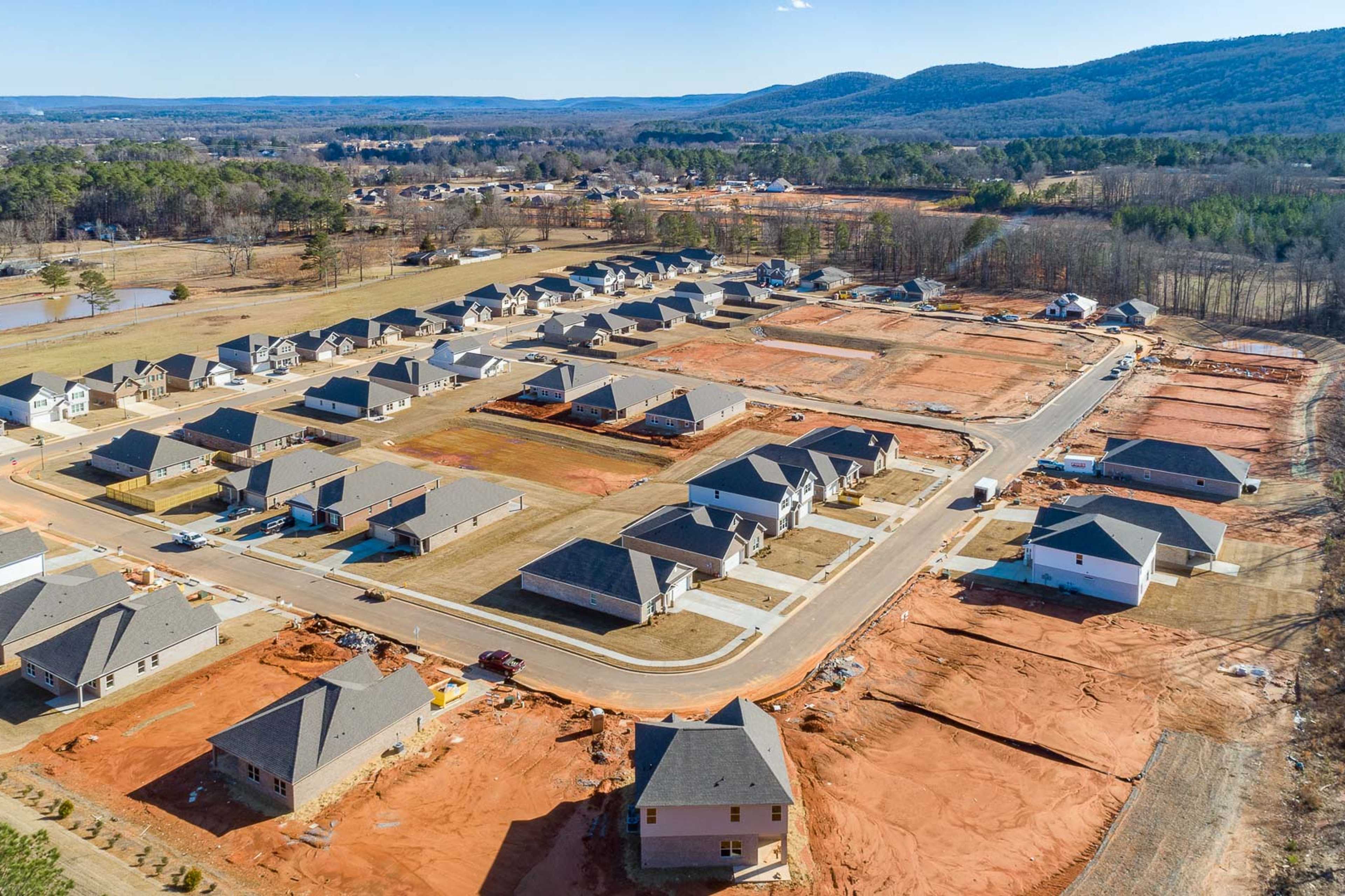 Aerial view of new homes under construction in Monteagle Cove, Owens Cross Roads, Alabama with wooded hills backdrop