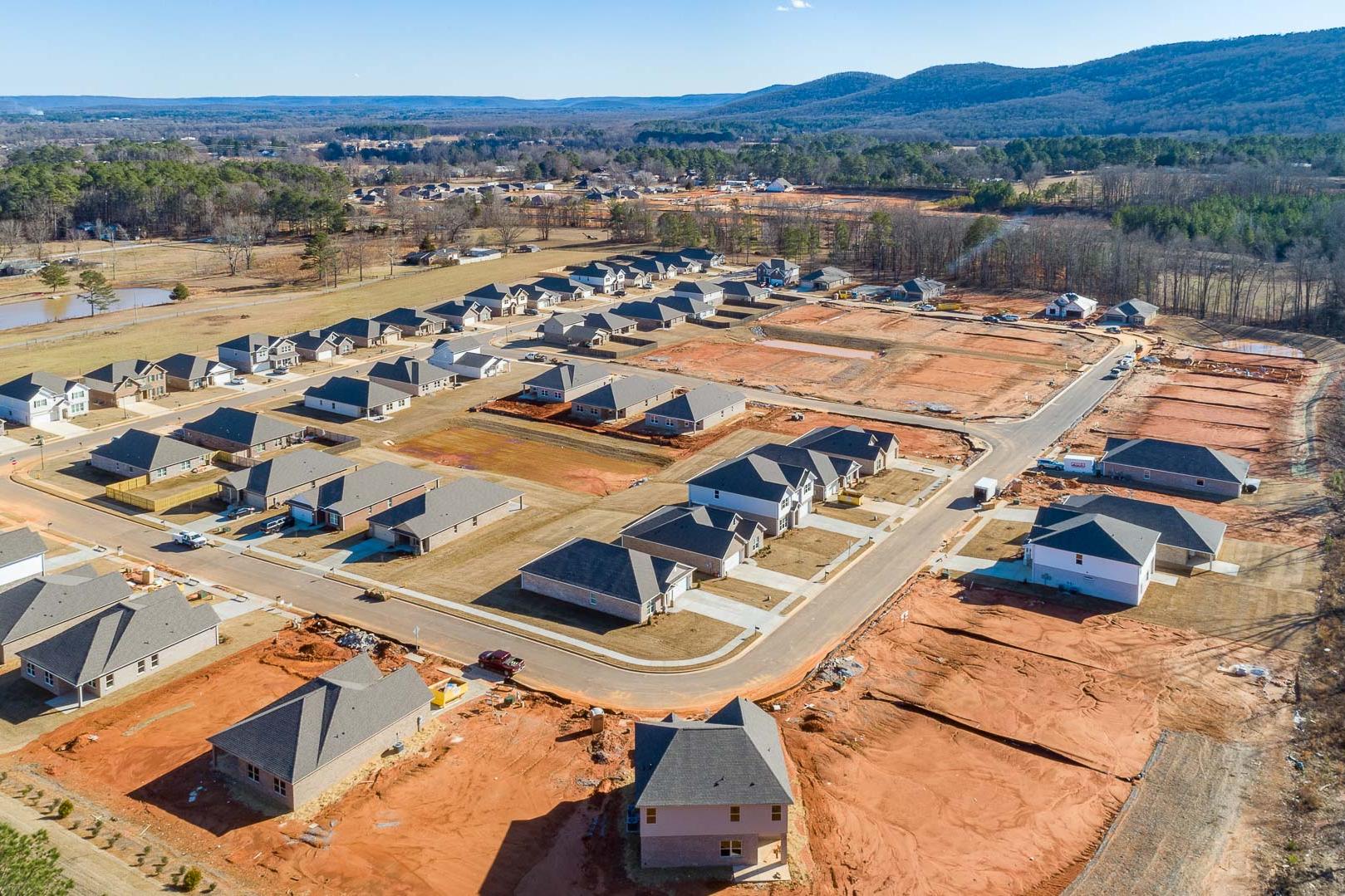 Aerial view of new homes under construction in Monteagle Cove, Owens Cross Roads, Alabama with wooded hills backdrop