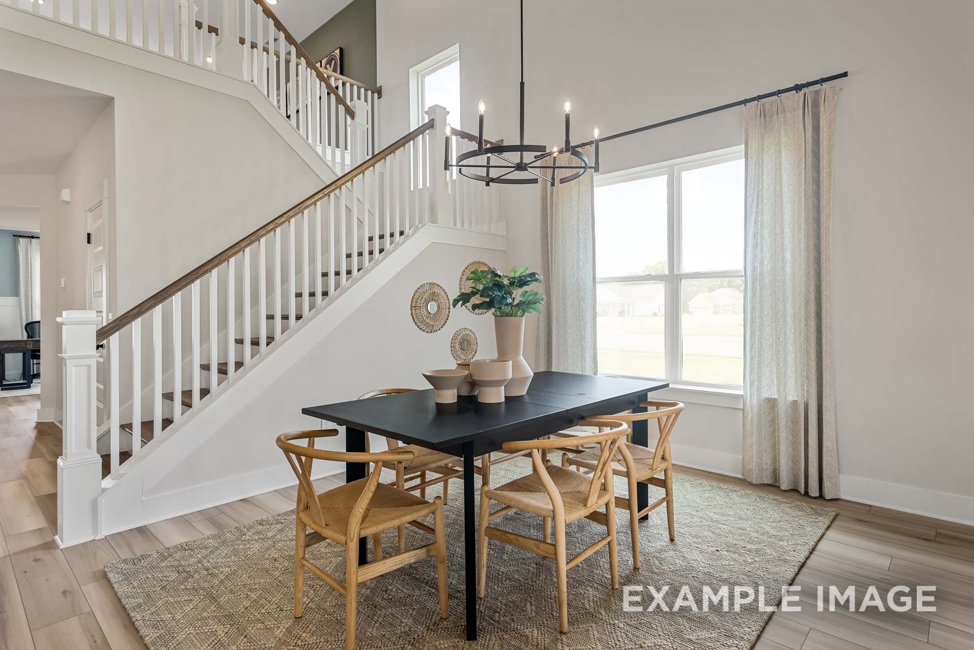 Bright dining area in The Ridgeport by Davidson Homes featuring staircase, chandelier, and natural light in Mt. Juliet, TN.