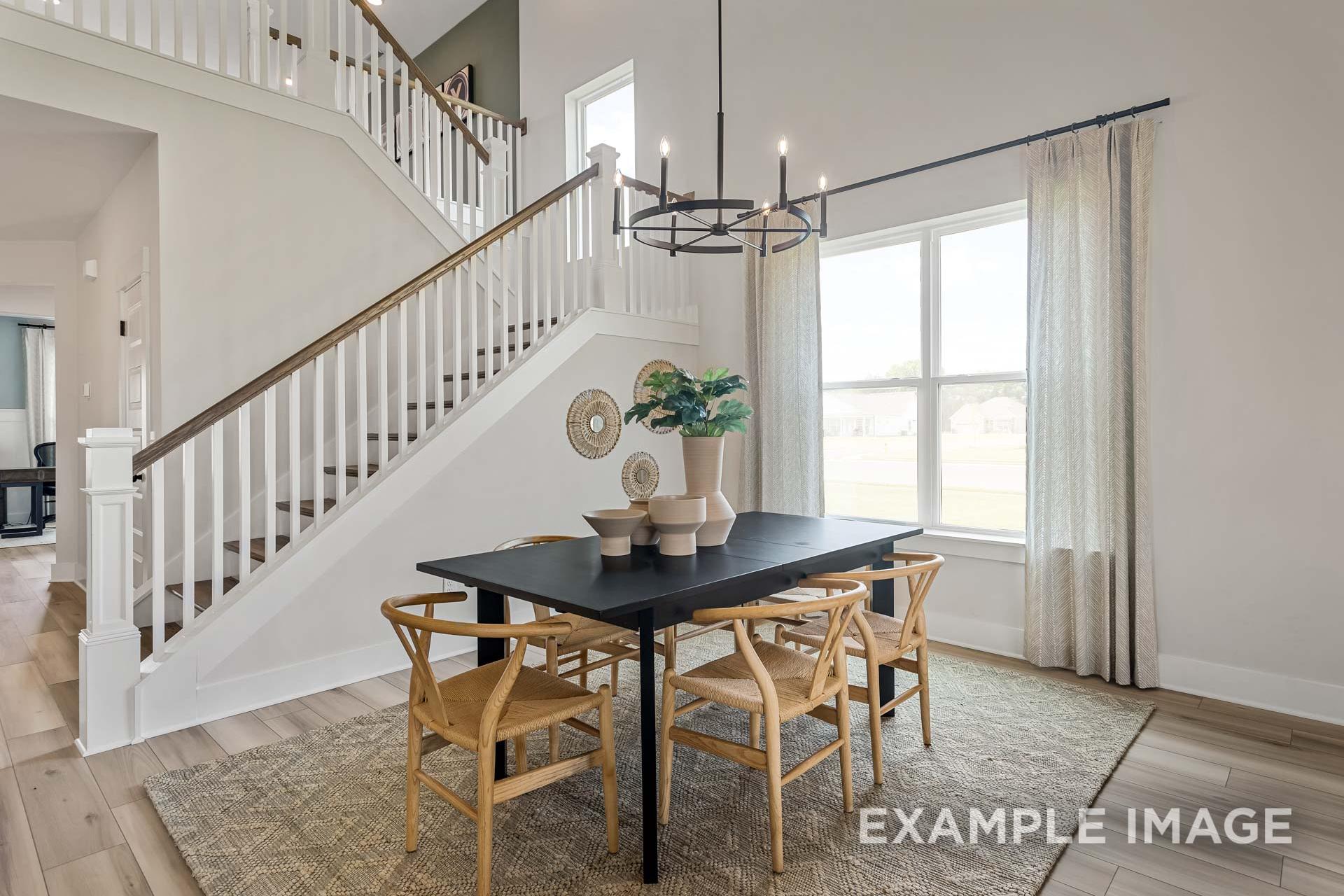 Bright dining area in The Ridgeport by Davidson Homes featuring staircase, chandelier, and natural light in Mt. Juliet, TN.