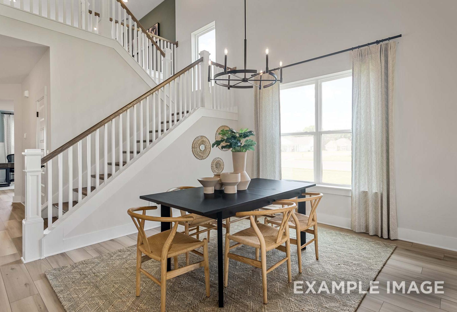 Bright dining area in The Ridgeport by Davidson Homes featuring staircase, chandelier, and natural light in Mt. Juliet, TN.