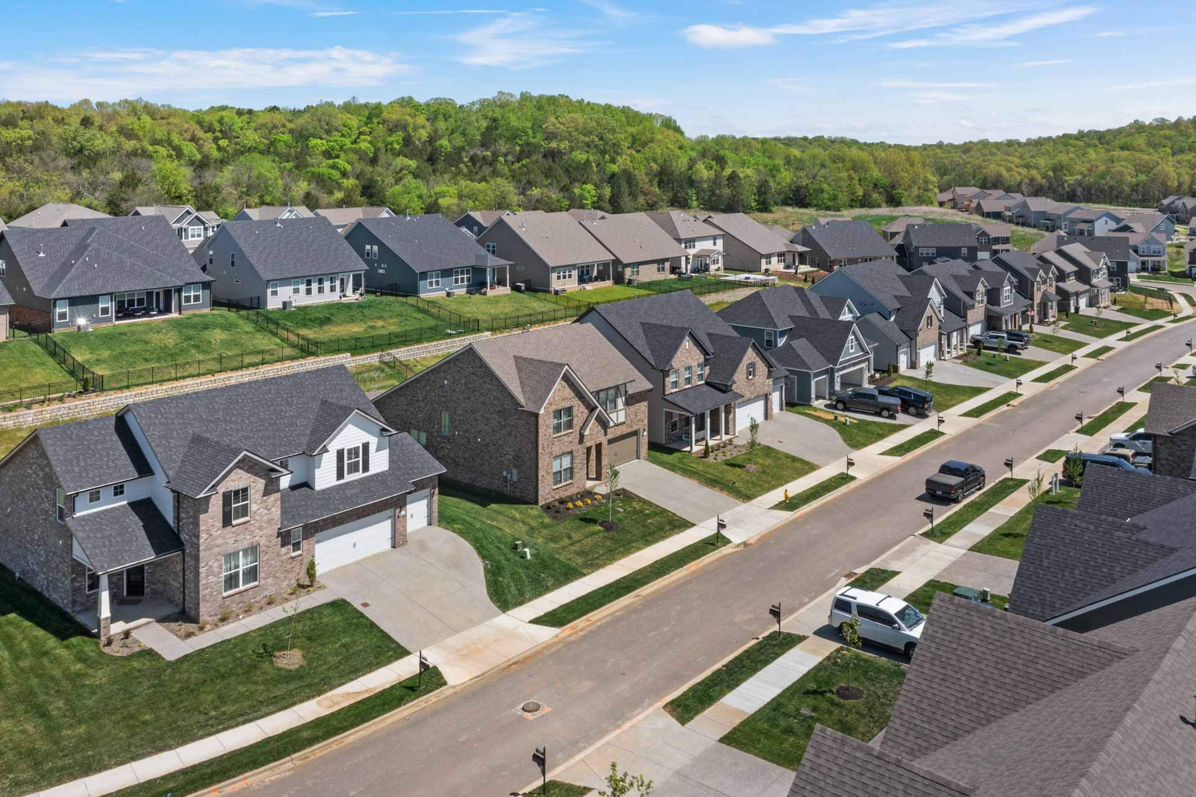 Aerial view of modern brick homes lining streets in Carellton, Gallatin Tennessee by Davidson Homes with lush green lawns