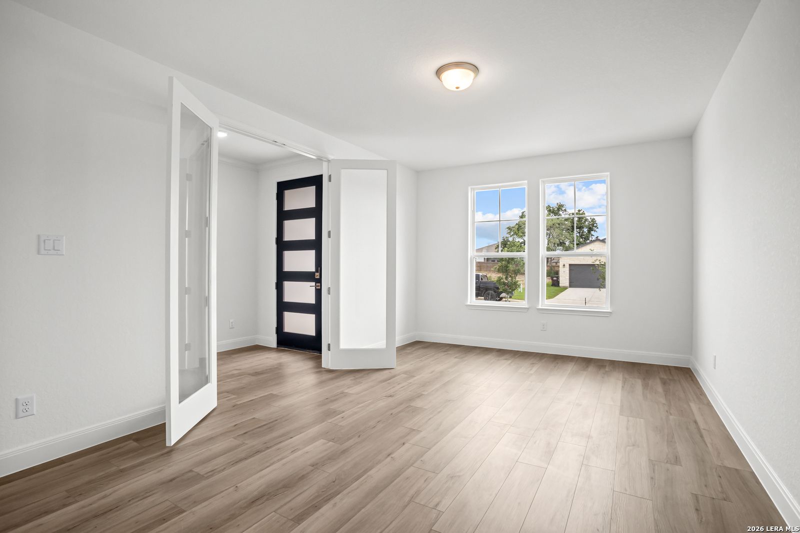 Bright home office or flex room with French doors and wood-look flooring in The Lanier G floor plan, Castroville, TX.