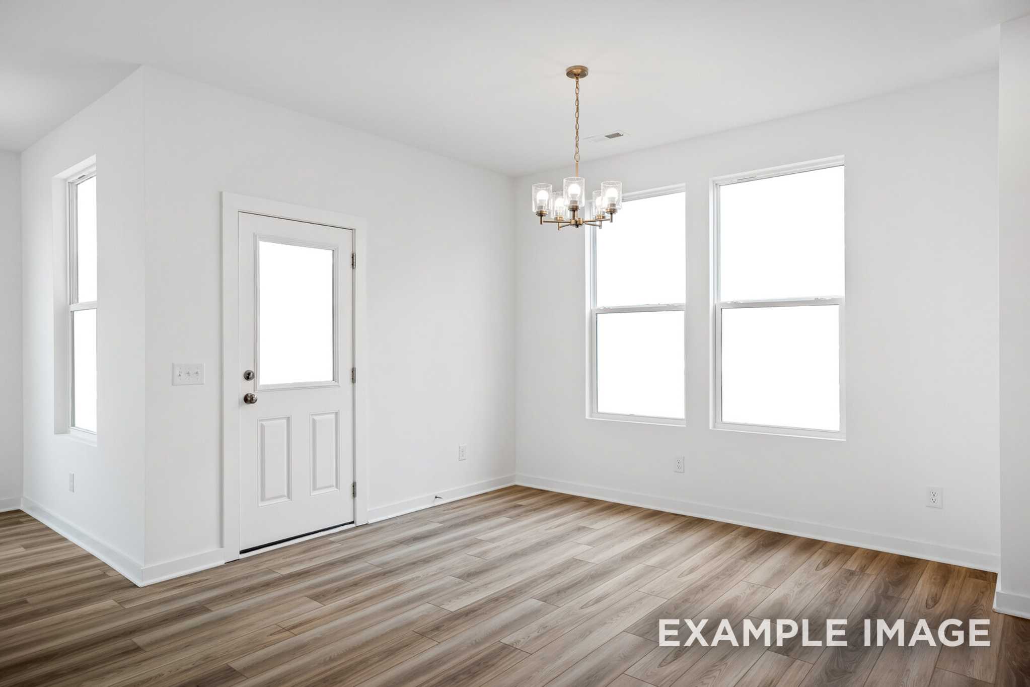 Bright dining room in The Murray B home featuring white walls, large windows, chandelier, and luxury vinyl plank flooring