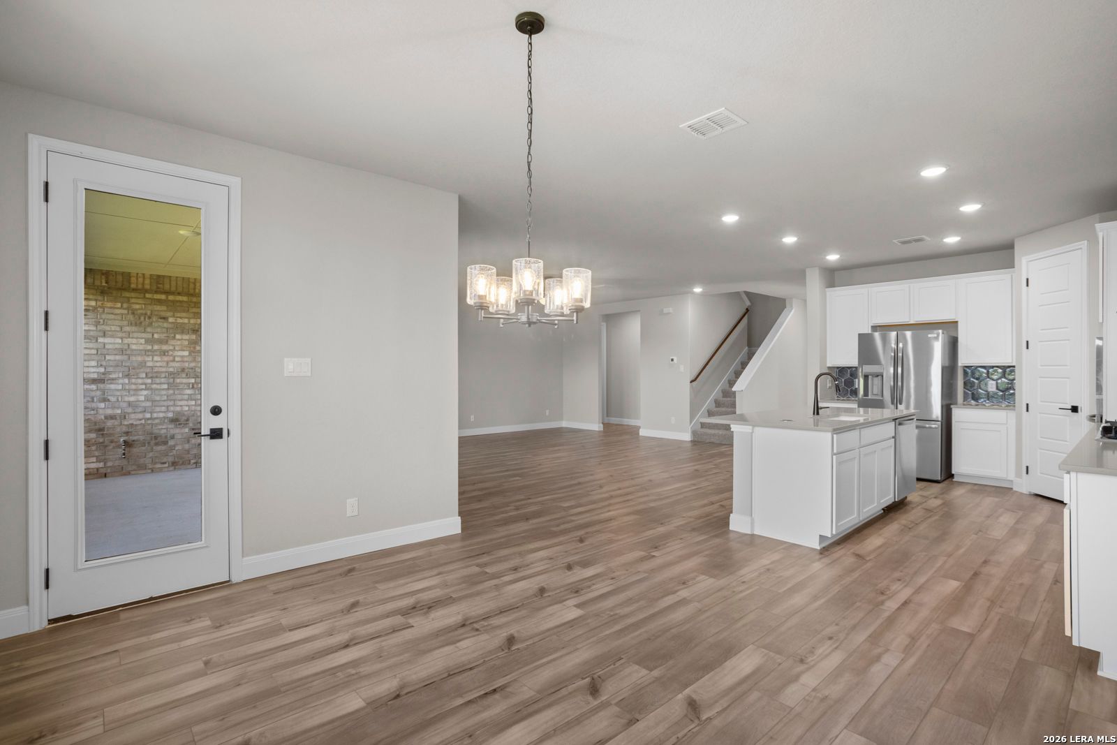 Open-concept kitchen and dining area with modern white cabinetry in The Jennings G floor plan at Ladera, San Antonio.