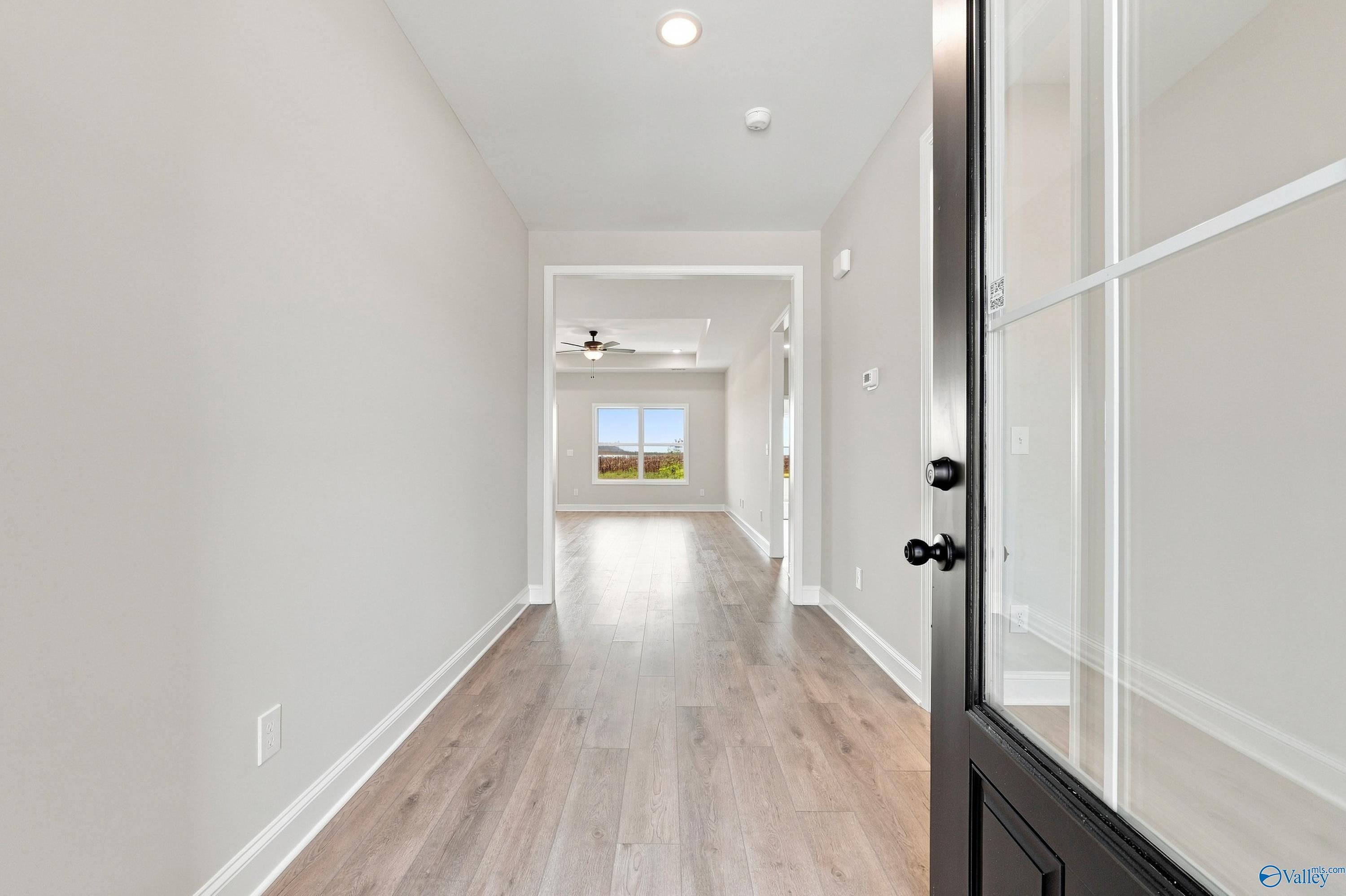 Bright entryway with luxury vinyl plank flooring and black front door in Davidson Homes Montgomery D plan, Athens, Alabama