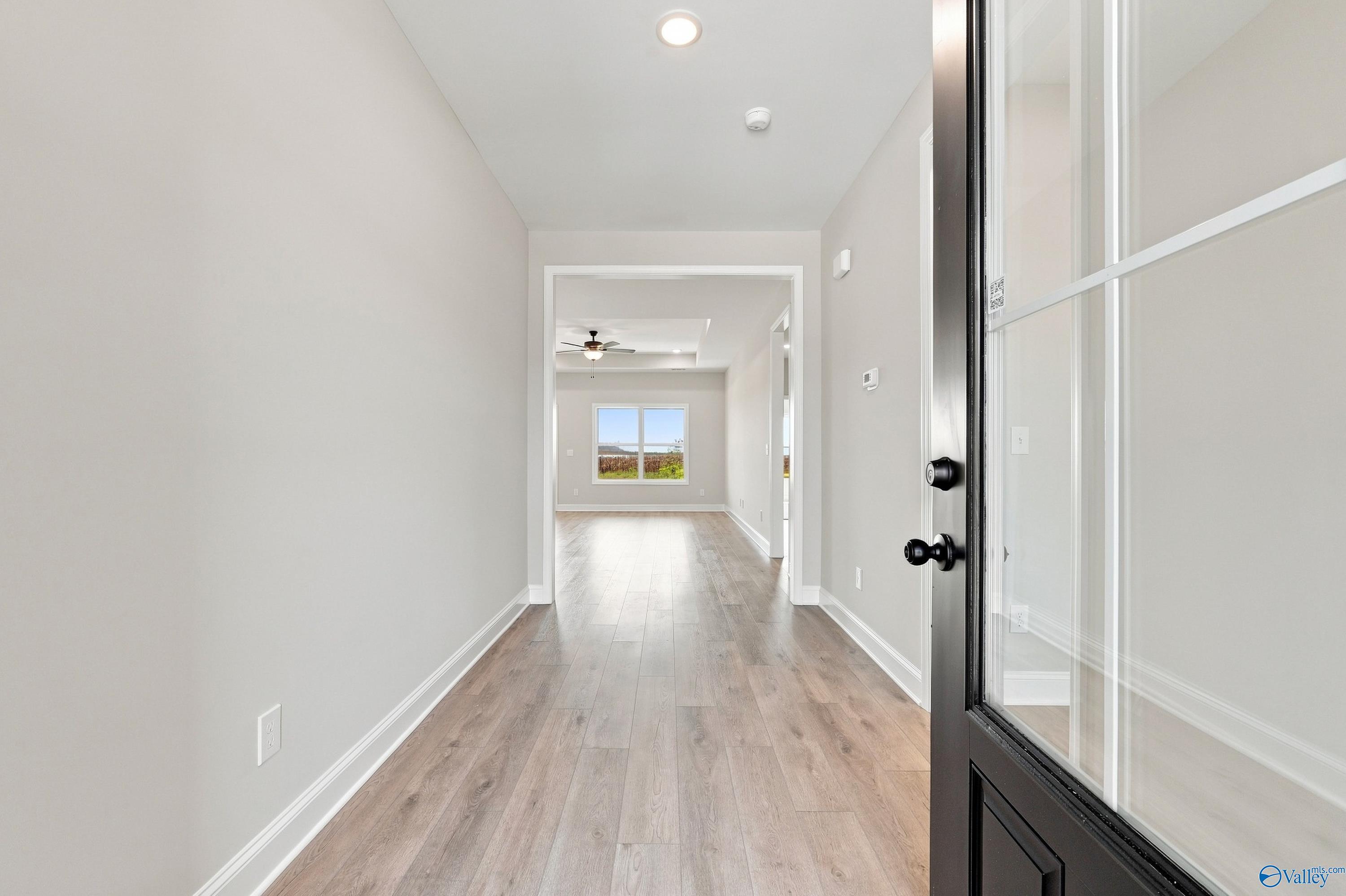 Bright entryway with luxury vinyl plank flooring and black front door in Davidson Homes Montgomery D plan, Athens, Alabama