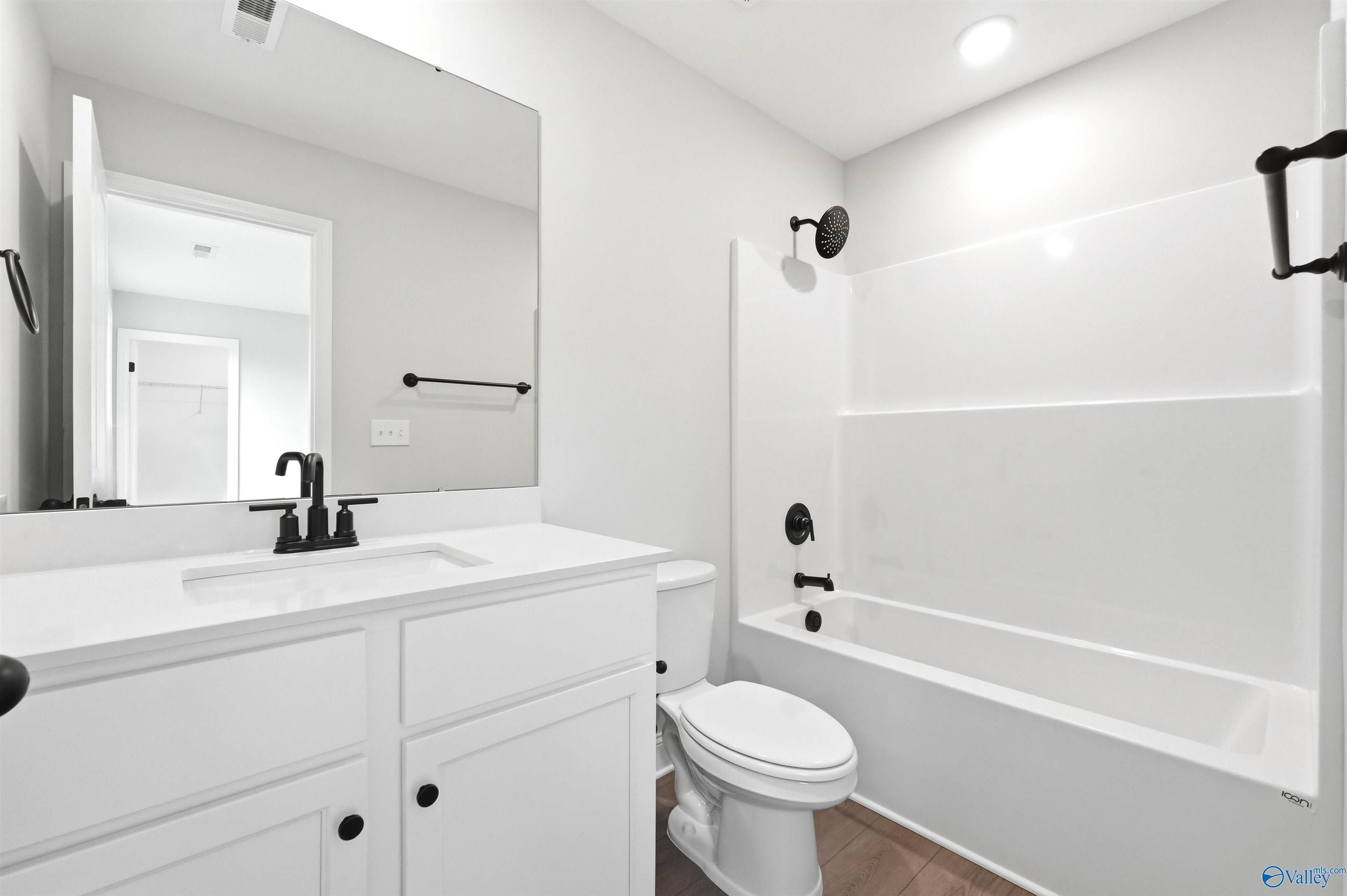 Modern bathroom with white vanity and tub-shower combo in The Chelsea D floor plan at Berry Cove, New Market, Alabama.