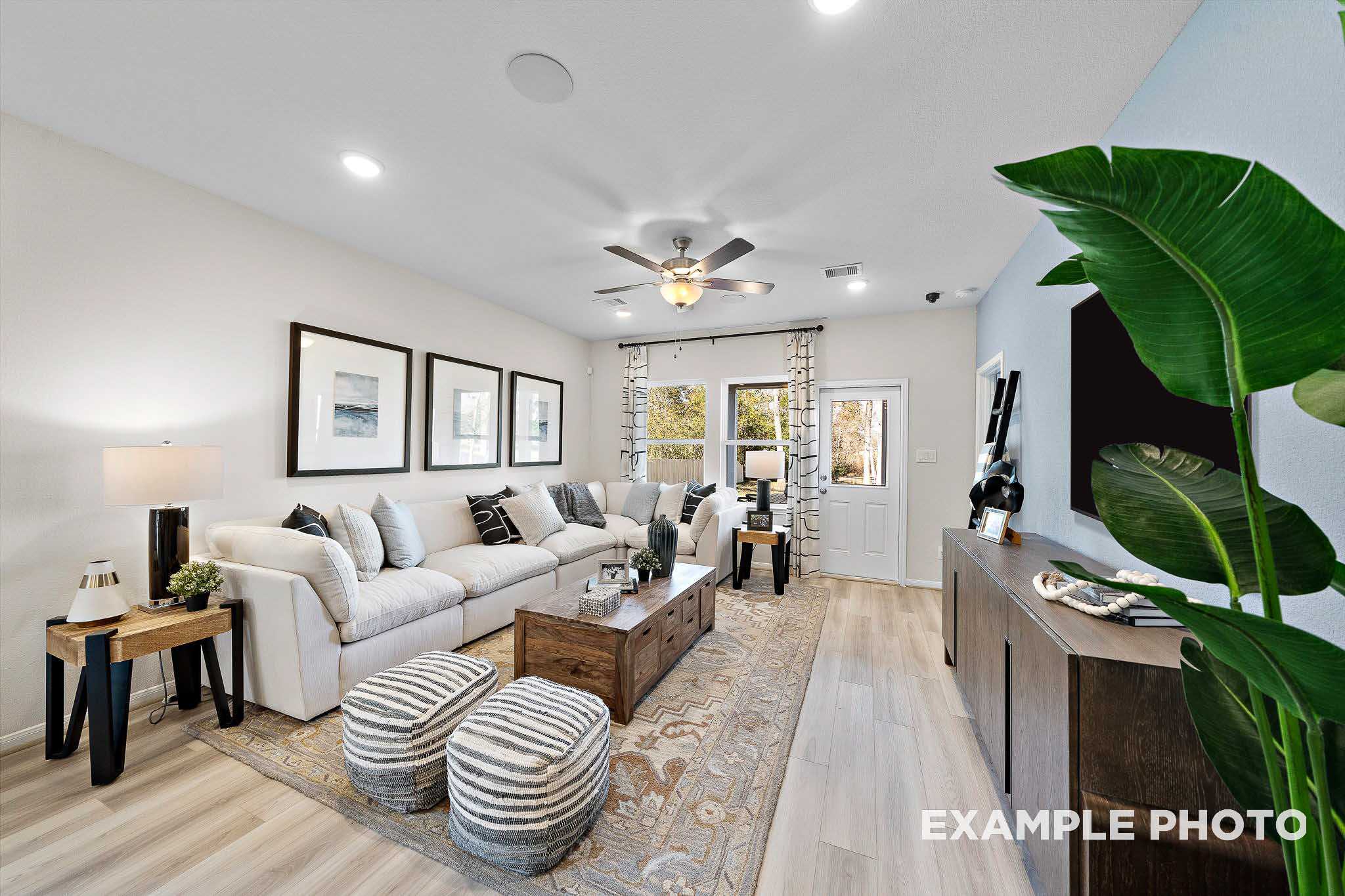 Modern living room with white sectional sofa, wooden coffee table, area rug, and potted plant in Davidson Homes The San Marcos D, Agave, San Antonio