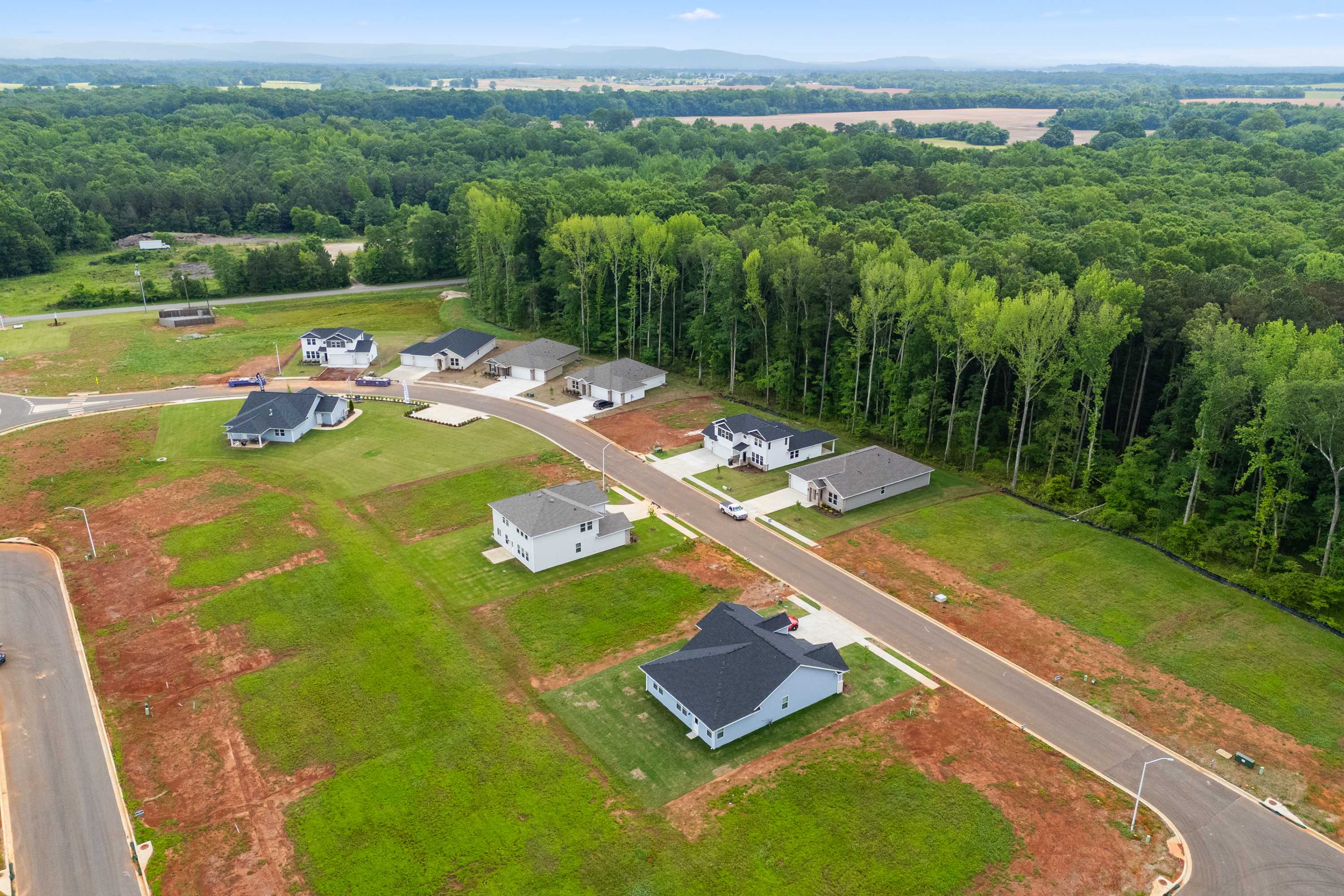 Aerial view of Forest Glen neighborhood in Hazel Green Alabama with new Davidson Homes amid lush forests and open fields